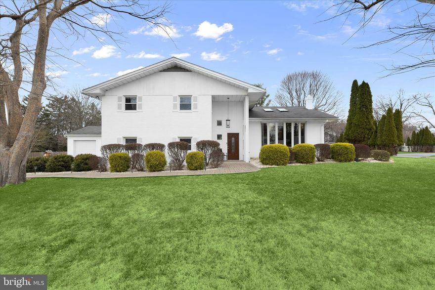 Presenting this exceptional one-of-a-kind home in the sought-after Long Meadow Estates in Pikesville, offering five bedrooms and three full bathrooms, spread across four levels. Multiple thoughtful additions over the years have expanded this sprawling residence, creating a home that truly feels custom built. Set on a level half-acre corner lot, this home has generous space for everyone both inside and out. Step inside to discover an abundance of natural light, beginning in the inviting front living room with a sun-filled bay window and a vaulted ceiling with skylights. Rich hardwood floors, crown molding, and recessed lighting continue into the dining room, providing a comfortable setting for gatherings of any size. Prepare your favorite meals in the eat-in kitchen, complete with a center island with seating, ample cabinets for storage, and appliances including a Bosch dishwasher and refrigerator/freezer, a JennAir gas cooktop, and double wall ovens. Just beyond, the sunroom addition boasts a soaring cathedral ceiling with skylights, oversized windows, and a wood-burning fireplace. Designed for year-round enjoyment, it offers a relaxing space with direct access to the patio and backyard. The upper level hosts the primary suite, complete with a separate sitting room with three closets, a spacious bedroom with a walk-in closet, and a well-appointed ensuite bathroom featuring a walk-in shower, jetted tub, and dual-sink vanity.  Completing the upper level are the second and third bedrooms, along with a hall bathroom. The finished lower level has two additional bedrooms and a third full bathroom with a walk-in shower. A comfortable family room with a cozy wood-burning fireplace and sliding glass doors outside provides additional living space, while a versatile den with a wet bar and garage access is ideal for an office or potential bedroom. The basement level offers laundry, extensive storage including two walk-in closets, and flexible space for a gym or hobbies. Outside, the backyard is designed for both relaxation and entertaining, featuring a paver stone patio with a convenient gas line hookup for a grill. Recent updates within the last few years include a new gas furnace (2025), gas water heater (2021), most of the kitchen appliances, sunroom skylights and windows, driveway resurfacing and more. Additional highlights include a generator, electric vehicle charger, zoned heating and cooling systems.