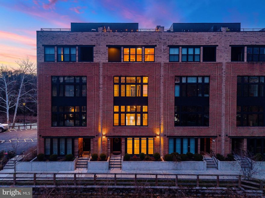Positioned along both the Schuylkill River and the Manayunk Canal, this five-bedroom, five-level townhome is one of only two buildings in the sensational Locks community with unobstructed dual-water views and approx. 5 Years Left on the TAX ABATEMENT.  The home is wrapped in floor-to-ceiling, 8-foot windows that capture natural light and water views on every level. Wide-plank hardwood flooring runs throughout, and a private elevator provides seamless access to all floors. The entry level includes a TWO-CAR GARAGE with EV charger, multiple storage closets, and a flexible bonus space suitable for a gym, studio, or additional living area. The main living level features an open-concept layout anchored by an eat-in kitchen with quartz countertops, oversized center island, pantry storage, and premium appliances including a Sub-Zero refrigerator, 6-burner Wolf gas range with built-in hood, and Wolf drawer microwave. The home has two separate living and family rooms, providing plentiful space to entertain, including a dry bar with beverage refrigerator, a separate dining area, and a conveniently located powder room. The third level offers three bedrooms, including one with an ensuite bath featuring a glass-enclosed tiled shower, along with a bathroom with dual-sink vanity. and tub/shower combination. A dedicated laundry room is also located on this level. The entire fourth floor is dedicated to the primary suite, featuring a bedroom with river views, a walk-in closet, custom white gloss built-in cabinetry, and a private office or optional fifth bedroom. The spa-inspired primary bath includes a soaking tub positioned to capture water views and a glass-enclosed shower with dual shower heads, rain shower, handheld wand, and built-in bench. This level also includes a wet bar with wine refrigerator and an outdoor seating area directly off the suite. A rooftop terrace crowns the home with unobstructed panoramic views of both the river and canal. Designed for entertaining, the terrace features built-in SONOS speakers and is pre-wired for an outdoor television. Additional features include SONOS ceiling speakers in the kitchen, family room, primary suite, and rooftop terrace; Lutron programmable electric shades; smart door locks; smart thermostat; and elevator access to every level. The home is adjacent to a community parking lot, providing convenient guest parking. There is also bridge access to Main Street, which is only a few short minutes away. Located along the Manayunk Canal and Tow Path Trail, the home offers direct access to scenic riverfront walking and biking paths, with close proximity to Main Street Manayunk’s restaurants, cafés, galleries, and shops, including Pilgrim Roasters, The Goat’s Beard, Winnie’s, Jake & Cooper’s, and La Colombe Coffee. Nearby recreational anchors include Pretzel Park and the Schuylkill River Trail. The Manayunk SEPTA Regional Rail station provides service to Center City Philadelphia in approximately <25 minutes. Convenient access to I-76 connects quickly to I-676 and I-95, offering efficient routes to Old City, Society Hill, and Philadelphia International Airport, as well as north–south travel along the Delaware River corridor.