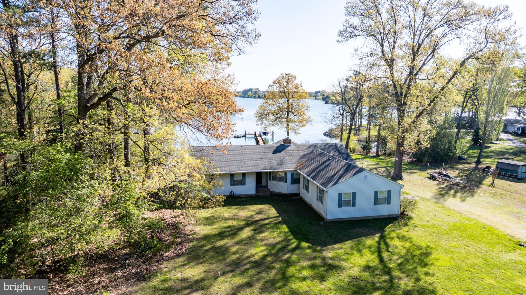 Tucked away on Elbert’s Cove, this one-level waterfront home offers a peaceful retreat on approximately 3 acres. With 3 bedrooms and 3 full bathrooms, the layout is thoughtfully designed for comfort and easy living. Multiple living spaces include a large recreation room with pool table, a living room with a cozy brick fireplace, and a waterside family room with built-ins and an adjacent dining area.
The open kitchen, featuring two breakfast bars, flows seamlessly into the living and dining spaces—perfect for gatherings. A spacious screened porch and brick patio overlook the water, ideal for outdoor dining or relaxing after a day on the water. Enjoy the best of Eastern Shore living with a private pier offering approximately 3’ MLW, a rip-rapped shoreline, Jet Dock, and kayak and boat launch—right outside your back door.