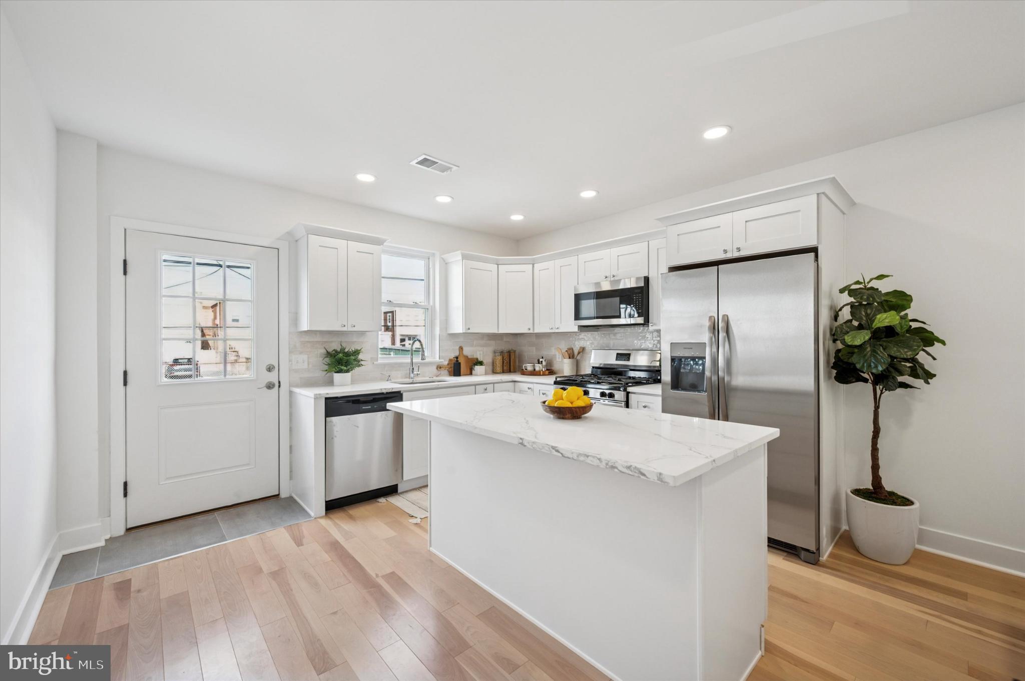 Newly remodeled 2-story house on 14x48 lot (1432 S Newkirk Street) and ADDITIONAL LOT that measures 14x47 (1433 S Dover Street) included in the sale! This amazing street-to-street opportunity in vibrant Grays Ferry was just completed, and includes a modern 2 bedroom/2 bath house with partially finished basement, as well as a fenced-in vacant lot, which is zoned as RSA5 and also accessed on Dover Street. They are being sold together (but are separate parcels), which would allow an owner occupant to have parking and/or a gigantic yard (or potentially build a whole other home)! The lots on Dover were deeded to the property owners on Newkirk with a 25 year covenant that they would not be developed, which expired on 5/19/2023. That means that this lot could potentially be developed as another residential property, as it is zoned RSA5. Buyer is responsible for verifying potential uses for the lot with the City prior to purchase.
The remodel of this two-story home (which included a rear addition) was just completed in 2025 and features a thoughtfully designed interior that maximizes space and light. Enter into the property via its front porch on Newkirk Street and you'll find an open floor plan that seamlessly connects the living, dining, and kitchen area, creating an inviting atmosphere perfect for entertaining or relaxing. Beautiful hardwood floors flow throughout, enhancing the warmth of the home. The modern kitchen is the highlight of this home, with plenty of storage and an island. It features white Shaker cabinetry, stainless steel appliances, and quartz countertops. The kitchen lets out onto a small rear yard, with the additional lot to the rear of that. Imagine having an additional 47 foot long yard to the rear of your property for parking, pets, barbecues and more! In the basement, you'll find an open finished space and utilities and laundry in a separate room in the rear. On the second floor are two generous bedrooms and two full bathrooms. This is a perfect opportunity for an investor or end user, close to shopping, major highways, and more, in growing Grays Ferry.