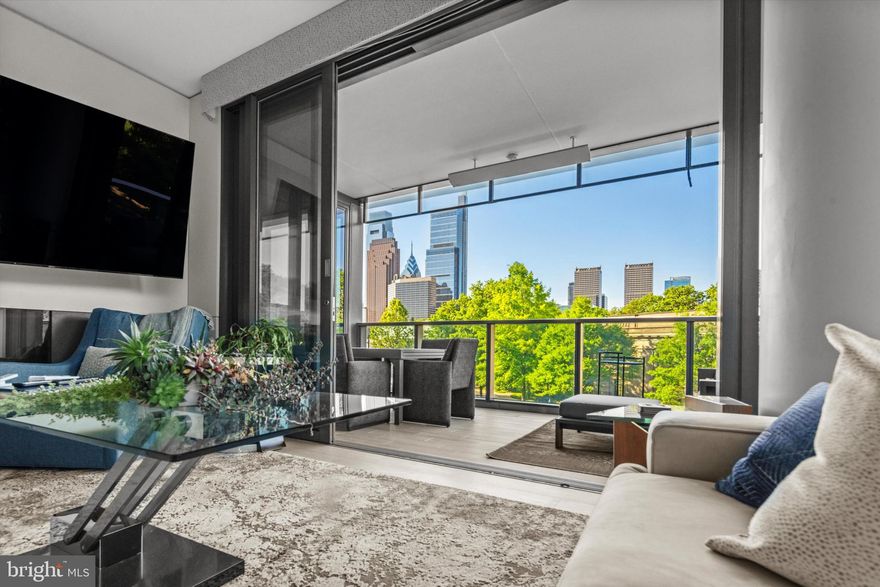 *Seller has an assumable mortgage at 2.875% (you must still qualify through the lender) AND there is over 6 years remaining on the tax abatement*.  Do you want to wake up in the morning amongst mature trees, surrounded by museums, all while enjoying the convenience of city living?  Walk out your building door for your morning coffee, visit your pilates studio or run along the Schuylkill, walk along the tree-lined streets, swing by Whole Foods to pick up food for lunch to eat on your beautiful outdoor terrace that overlooks the city skyline as the fountain runs in the courtyard, and decide where you’re headed for dinner to meet friends… all while being less than 20 minutes from Philadelphia International Airport for the early Monday morning work flights, or, better yet, those weekends you decide on a spur of the moment trip!   This stunning 2-bedroom, 2 full and 1 half bathroom apartment in convenient Logan Square with deeded private garage parking spot and storage might just be the one for you.  Facial recognition elevator access brings you directly into your modern residence that offers seamless indoor-outdoor living via a fully retractable and automatic glass wall that leads to an oversized outdoor space - perfect for those gorgeous warm summer evenings!  With walls of glass and the upcoming summer sun, you can use the hardwired electric shades throughout the home when you need a little shade, and both bedrooms are also equipped with black-out shades for days where you feel like sleeping in.  The living space is open and sleek with a chef’s kitchen that features premium Wolf, Cove, & SubZero appliances and 59 bottle built-in wine storage, with enough space to create some cozy areas…because this is home, after all.  The gorgeous primary suite boasts an enormous walk-in closet and a spa-like bath with heated floors & automatic frosted glass that allows for unbelievable natural light while maintaining privacy, and the generously sized second bedroom includes its own well-appointed en-suite bath.  This one floor luxury living is complete with a beautiful powder room and nicely sized laundry with custom cabinetry.  Residents in this spectacular building enjoy world-class amenities, including 24-hour concierge service, a private parking garage, an indoor lap pool, a fitness center, and a private outdoor patio. The exclusive house car provides transportation within city limits and to Philadelphia International Airport - the ultimate convenience.