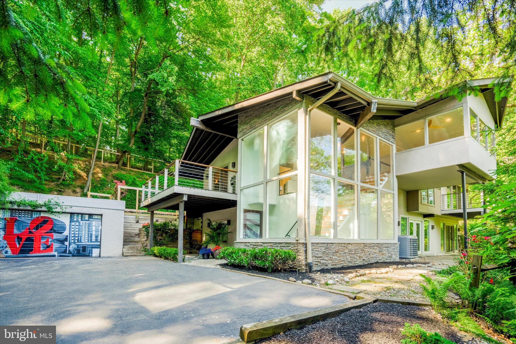 Enviably situated atop a serene hill, this magnificent eclectic modern abode serves as a haven for nature aficionados.  Affectionately dubbed "Happy Hill", this luxurious estate encompasses four bedrooms, three full baths, a two-car garage, and a stunning in-ground pool.  Each unique outdoor living space draws you in and creates a different experience. Meticulous attention to detail is evident in the countless upscale enhancements throughout the property.  

As you meander up the picturesque driveway, you are instantly embraced by a sense of seclusion and tranquility on over 2 sprawling acres. Upon entering, you are greeted by a breathtaking wall of windows, bathing the space in abundant sunlight and offering panoramic views that stretch for miles. The family room features a soaring vaulted ceiling with exposed beams and a majestic floor-to-ceiling stone gas fireplace adorned with bespoke stone spheres—perfect for cozy winter evenings and cool summer nights. A versatile loft area offers an additional sanctuary for relaxation and admiration of the outdoors.

Adjoining the living room is the versatile kitchen, showcasing pristine quartz countertops, a functional island, cutting-edge appliances, and a state-of-the-art Keurig Profile Refrigerator. The kitchen conveniently opens to a generously sized deck, perfect for al fresco dining and entertainment. The kitchen flows into the dining room featuring a skylight, enhancing its brightness, and sliders for easy outdoor living.

The primary bedroom suite exudes luxury, complete with a private balcony, new plush carpeting, a generous customizable walk-in closet, and an en-suite bathroom. The primary bathroom features a spacious shower with a built-in bench, a rain showerhead, waterfall, wall jets, a floating Restoration Hardware sink/cabinet, a soaking tub, heating lamps, and a sleek tankless floating toilet.

A second main floor bedroom, newly renovated adjacent bathroom, and laundry room complete this level. The tastefully remodeled walk-out lower level includes an additional lounge area, a gas fireplace, and newly installed carpeting. Additionally, the lower level comprises two more bedrooms, another newly renovated full bath, a large storage area primed for conversion into more living space, and access to the outdoors which bathes the area in natural light.

The verdant backyard serves as a tranquil oasis, with an in-ground pool enveloped by large-scale plantings for ultimate enjoyment and privacy. This private retreat is truly unparalleled in its appeal.  

Notable recent upgrades include a new HVAC system (2020), hot water heater (2020), freshly painted (2023), new carpets (2023), and multiple newly renovated bathrooms (2023), a new pool pump (2023) and estate post and board fencing (2023) around the back yard. Conveniently located just minutes from Wayne, King of Prussia, fine dining, shopping, and major highways, this exquisite property is a must-see. Schedule your private viewing today!