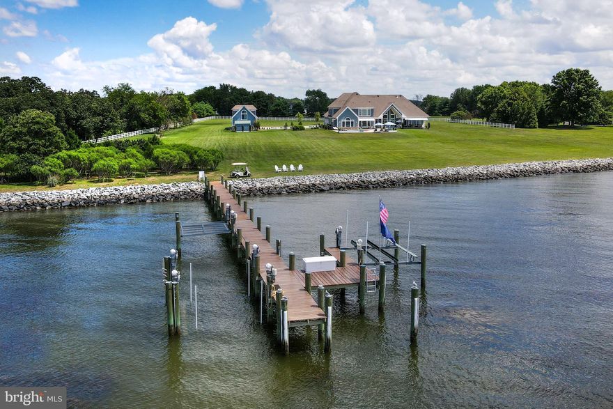 LIKE NEW this spectacular Eastern Bay estate on over 5 private waterfront acres with panoramic views all the way to Kent Island. Custom built in 2012 and completely renovated in the last two years by the current owner, this home offers 7,000+/- sq.ft of living space, 4-car attached garage, multi-car detached garage with separate living space above & exercise room, beautiful brand new pool with hot tub, extra large decking across back of house, 400 +/- feet of rip rapped water frontage and 150  deep water pier with boat lifts and slips. The main residence features a sunbathed contemporary open floor plan with views of the bay from almost every room. The first floor offers a foyer and living room with cathedral ceiling, gourmet eat-in kitchen with breakfast area, dining area, great room, TV room with gas fireplace and wet bar, his & her office, powder room, laundry room, master suite, 2 additional bedrooms with en-suite baths, and a covered porch off of the living room and master suite. The Master suite features a sitting area with gas fireplace, luxurious master bath with separate vanities, steam shower, floating tub, laundry, and large walk-in closet. The second-floor features 2 additional bedrooms with en-suite baths, a large recreation area with wet bar, and a powder room. The main house is completed by a full footprint crawl space, perfect for storage. The detached multi-car garage is currently a 3-car garage with the 4th bay converted to an exercise room with a powder room, but is easily converted back to a full 4-car garage. Upstairs is a loft/bedrooms & living space perfect for large gatherings or guests with a full bathroom and wet bar. The 150 ft. pier offers multiple lifts - (1) 25,000#, (2) 10,000# & flat lift for kayaks/paddle boards/peddle boards up & down launching. There is a matching equipment storage shed on the property as well. Check out the 3D rendering in our virtual tour to take a virtual tour of the main house and guest house.