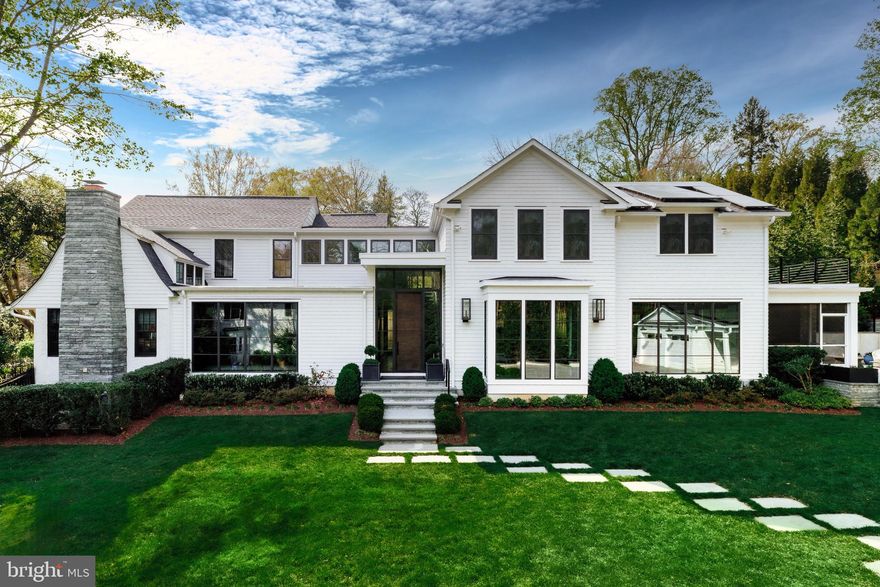 Set amidst mature trees and manicured grounds in the heart of beloved Somerset, 4709 Dorset Avenue is where storied architecture meets modern refinement—an estate that whispers of beauty, comfort, and enduring style. Behind its Victorian-inspired façade lies a collaboration between GTM Architects, Sandy Spring Builders, Zoe Feldman Design, and lush landscaping by Fine Earth and McHale. Automatic gates reveal verdant grounds, where a walkway of oversized flagstone slabs leads to the towering glass front entrance.

Inside, the grand foyer sets a refined tone with Farrow & Ball hues, an Urban Electric fixture, and wide-plank white oak flooring. A hand-plastered feature wall by Nicolette Atelier, Chesneys limestone mantel, and custom reading nooks define the cathedral-ceilinged formal living room. The family room features accordion doors opening to a heated all-season porch with a double-sided gas fireplace.

The dining room is flanked by Urban Electric sconces and framed by floor-to-ceiling gridded metal windows. Adjoining it, the butler’s pantry features a honed marble counter, antique mirror backsplash, hammered brass sink, and Sub-Zero wine storage. Nearby, the kitchen offers a commercial-grade appliance suite, custom inset cabinetry, Urban Electric lighting, a Shaw’s England farmhouse sink, thick-edge marble countertops, and Petite brass hardware—equal parts gathering space and culinary showpiece.

The family entrance leads to a well-appointed mudroom with built-in lockers and a wallpapered powder room with a Waterworks mirror.

Upstairs, the serene primary suite features automated blackout blinds, private backyard access, and a generous walk-in closet. Its spa-inspired bath includes radiant heated floors, Waterworks fixtures and tile, a body jet shower, and private water closet. Three additional en suite bedrooms feature custom millwork, tailored finishes, and bespoke storage. A well-appointed laundry room with quartzite countertops completes the level.

The lower level offers a spacious rec room with a quartzite wet bar, temperature-controlled Porcelanosa-tiled wine room, and a mirrored fitness studio. A fifth bedroom with full bath and walk-in closet adds flexibility. Additional laundry and utility rooms are seamlessly integrated.

A rare amenity, the detached garage includes a fully outfitted guest suite with private entrance, kitchenette, full bath, Wi-Fi, Alpha shelving, and ample storage—ideal for guests, remote work, or multigenerational living.

Outdoors, the flagstone patio features a full outdoor kitchen with built-in Coyote grill and fridge. Infratech heaters and glowing Bevolo lanterns transform the porch into a year-round retreat, while a bamboo wall ensures privacy. A vegetable garden by Love & Carrots, manicured lawn, turf area, smart irrigation, and architectural lighting round out the outdoor experience.

A true smart home, the property includes Lutron and Sonos systems, Vintage Home security with spotted cameras, dual 200-amp panels, and layered HVAC, water treatment, and solar solutions.

Bounded by Kenwood, Friendship Heights, the Chevy Chase Club, and Bethesda Row, this is one of the Capital Region’s most sought-after locations. Timeless, elegant, and masterfully crafted—4709 Dorset Avenue is the poster child for tasteful luxury.