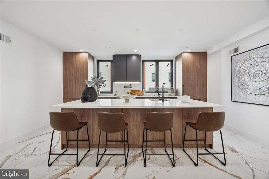 Introducing Parkside South, Philadelphia’s premier gated enclave of contemporary luxury townhomes in Packer Park. Experience refined city living in this private community featuring a collection of 4- and 5-bedroom residences with two-car garages, 5 stop elevators, expansive rooftop decks, and approved tax abatements. Parkside South combines modern architecture, sophisticated design, and everyday comfort into one seamless lifestyle. Each home showcases an open-concept floor plan drenched in natural light through imported Italian floor-to-ceiling windows. Sleek Italian tile flows throughout, setting the tone for a clean, elegant aesthetic. This unit offers 4 bedrooms and 4.5 bathrooms, designed with every detail in mind, from thoughtful layout to premium finishes. The chef’s kitchen is a true showpiece, featuring cabinet-integrated appliances, a built-in wine refrigerator, an oversized central island for entertaining, and a spacious walk-in pantry. Upstairs, the primary suite serves as a private sanctuary with a spa-like bath that includes a soaking tub, rainfall shower, and radiant heated floors. Every secondary bedroom features an en-suite layout, balancing luxury with functionality. The rooftop deck elevates your living experience,  a stunning space to host guests or unwind while taking in the views of Philadelphia’s skyline, bridges, and sports arenas. Parkside South homes are equipped with smart home automation, allowing effortless control of dual-zone HVAC, lighting, surround sound, and garage systems directly from your phone or tablet. Designed for both comfort and convenience, each home includes secure gated access, private parking, and proximity to major highways, public transit, and the city’s top cultural attractions. Don't miss out on this opportunity to make Parkside South your home, reach out today!