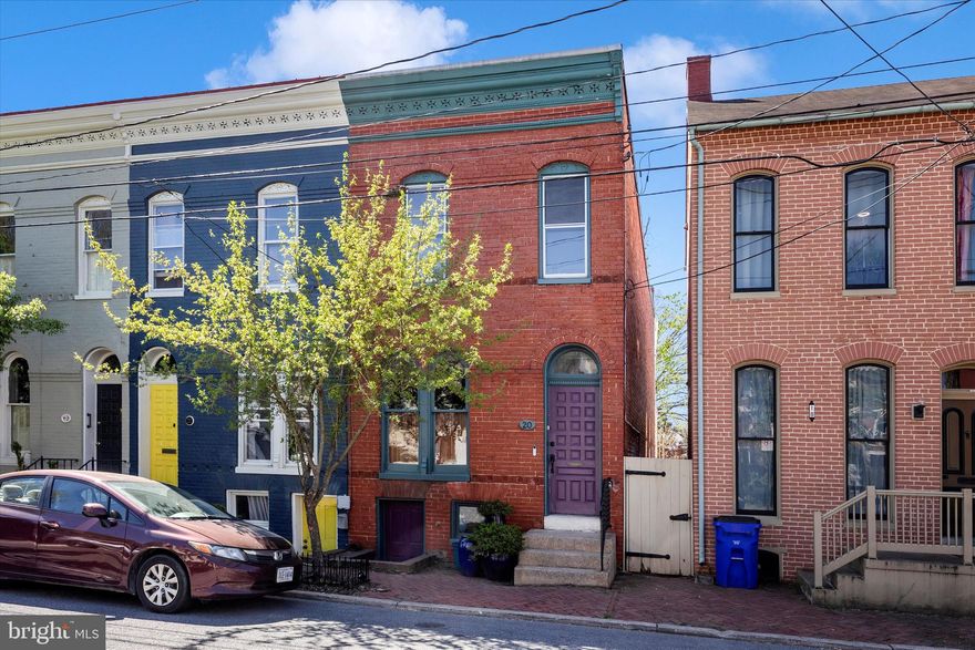Nestled on a quiet residential street in the heart of the Frederick Historic District, this 1900s Federal style rowhome blends historic character and modern updates with original hardwood floors throughout the home.   Walk down the street to the Farmers Market, vibrant art galleries and restaurants and enjoy all that City living has to offer in Frederick!  
The main level, with exposed brick and crown molding, offers an open floor plan flowing from the living room, dining room to the updated and sun-filled kitchen.  Everything has been freshly painted in neutral colors throughout the home. The kitchen has stainless steel appliances, granite counter tops, a gas stove with grill top and a separate butcher block workspace.  A bonus updated full bath, along with a washer/dryer, complete the main level.
Step outside to your backyard retreat featuring a brick patio with a deep fenced in backyard with a stone path leading to a firepit.  Perennial flowers will be popping up in time for Spring and Summer along with raised garden beds to grow your own vegetables and herbs.
Upstairs, you will find a spacious primary bedroom that overlooks the street from the front of the house and includes a large closet.  (Owner is offering the furniture outside of the sale of the home) The second bedroom also has a deep closet and the third bedroom is currently used as an office.  Access the porch from the third bedroom for your morning coffee and a beautiful view of your back yard oasis.   The full bath on this floor has also been updated.
The dry basement has a concrete floor, abundant storage space, a washing machine, sump pump and radon remediation system, for added peace of mind. 
This home is the ideal opportunity to enjoy the very best of downtown Frederick Living!
