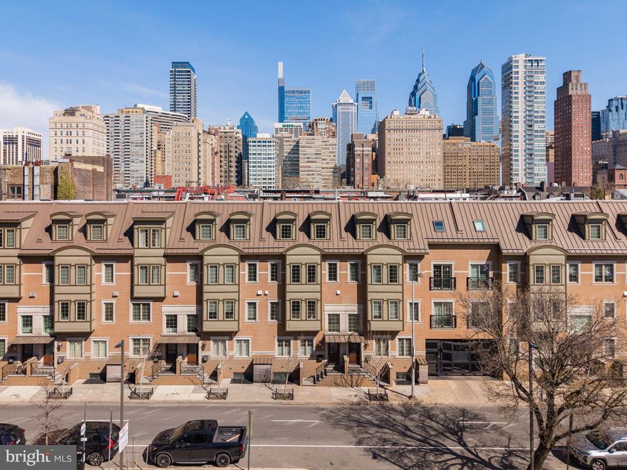 Welcome to The Lombard Estates—an exceptional luxury residence ideally situated steps from Rittenhouse Square, a short walk across the bridge to UPenn, CHOP & HUP & located in the prestigious Greenfield School Catchment! Offering over 4,100 square feet of impeccably designed living space, this expansive home blends sophistication, comfort & convenience in one of Philadelphia’s most sought-after locations. Complete with 4 bedrooms, 4.5 bathrooms, a finished basement, private elevator, and a 2-car garage, every detail has been thoughtfully curated for elevated city living. Topping it all off is a spectacular 2-tiered rooftop deck showcasing completely unobstructed skyline views—some of the most breathtaking in all of Philadelphia!  Enter through an elegant foyer, currently styled as a home office, with convenient access to the attached 2-car garage with generous storage. An in-home elevator enhances everyday convenience by allowing easy movement between all levels. It simplifies daily routines and adds flexibility, creating a more comfortable & functional living environment for a variety of needs over time. The second level unfolds as the heart of the home, thoughtfully designed for both daily living and elegant entertaining, with a spacious living & dining area highlighted by gleaming hardwood floors, custom built-ins, a gas fireplace, and charming Juliette balcony. The living room entertainment center features centralized control of built-in speakers, allowing you to enjoy music throughout the living & dining areas, kitchen and even the roof deck! The chef’s kitchen is impeccably appointed with premium appliances, including a Viking refrigerator, Wolf cooktop & double oven, a Miele hood, and Bosch dishwasher. Quartz countertops, high-end cabinetry, and a sleek backsplash blend functionality with sophisticated design. A discreet powder room completes this level. The third level offers 3 generously sized bedrooms with hardwood floors, 2 full bathrooms, and a dedicated laundry room with a Whirlpool washer/dryer + utility sink. The top level is devoted to the luxurious primary suite, where skylights fill the space with sunlight. This serene retreat features a spacious WIC with custom built-ins, and a spa-like bath. The luxurious bath is appointed with a NuHeat radiant floor heating system, a tiled shower, dual vanities, and a soaking tub designed for ultimate relaxation. Just outside the primary suite, a convenient wet bar makes entertaining effortless as you step out onto your incredible rooftop deck. Whether hosting guests or enjoying a quiet evening, the 2-tiered outdoor space offers ample room for dining, grilling, and taking in sweeping, unobstructed views of the city skyline. The roof deck is fully equipped for outdoor dining, featuring a kitchen with a BBQ, refrigerator, and sink. A built-in gas fire pit creates the perfect setting for evening cocktails under the stars. Have peace of mind knowing that the fiberglass roof was refinished in 2019 prior to installation of Trex style roof decking. The fully finished lower level presents an impressive extension of living space, featuring a generous family room, a thoughtfully designed bar for entertaining, and a temperature-controlled wine cellar. The level also features a full bathroom and can easily be used as private living space for an au pair as an alternative option. The basement houses an in-home water filtration system along with an plenty of finished storage space. Smart home features include a Control4 automation system that lets you manage lighting, temperature & security with ease. Set programmable timers for lighting & adjust the climate throughout the home—all from an app, with remote access via subscription. Enjoy nearby dining favorites like Rival Bros, Friday Saturday Sunday, Illata, Pub & Kitchen & Southgate. Rittenhouse Market is just 3 blocks away. The Schuylkill River Park, Markward Playground, tennis courts & dog parks are all close by!