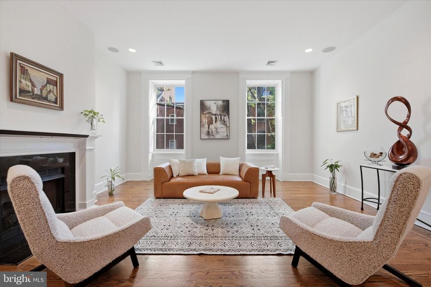Nestled within the Coles House Condominium on picturesque, tree-lined Clinton Street, often affectionately referred to as “Midtown’s Delancey” for its timeless beauty, historic charm, and unmistakable sense of place, this exceptional 3-bedroom, 3.5-bath residence with parking offers the grandeur and architectural presence of a classic townhome, paired seamlessly with the ease and convenience of condominium living.
Framed by a stately red brick façade and elegant white marble steps, the building makes a memorable first impression. Inside, a well-appointed lobby with controlled entry sets the tone, while a rear entrance provides effortless access just steps from your deeded parking space. An elevator delivers you directly to the second floor, where Unit 203 begins to unfold.
A welcoming foyer with coat closet opens into a breathtaking living and dining space defined by soaring ceilings, rich hardwood floors, and a gas fireplace that anchors the room with warmth and character. Expansive south-facing windows flood the home with natural light, and with nearly all windows recently replaced, including six restored historic façade windows, the home now offers both enhanced efficiency and preserved architectural integrity. Fresh paint throughout provides a crisp, clean, move-in-ready canvas.
The open dining area sits at the heart of the home, perfectly scaled for lively dinner parties or intimate evenings alike. Just beyond, the thoughtfully designed chef’s kitchen features stainless steel appliances, custom wood cabinetry, generous storage, and a wraparound island that naturally becomes the gathering place, whether for morning coffee, a glass of wine, or conversation that lingers long after the meal is over. A conveniently located powder room completes this level.
A graceful staircase leads to two spacious secondary bedrooms, each with its own full bath and ample closet space, one currently styled as a flexible office or den. A dedicated laundry room with additional storage sits just off the hallway, adding everyday practicality to the home’s elegant design.
The entire third floor is reserved for a truly special retreat: a stunning primary suite that feels like its own private sanctuary. Here, a generously sized bedroom with soaring ceilings overlooks acclaimed Clinton Street and is complemented by abundant closet space and a luxurious bath featuring a walk-in shower, soaking tub, and large marble double vanity. An additional staircase leads to attic storage, an uncommon and highly valuable bonus in city living.
Back on the main level of the building, residents enjoy a mail and package room, bicycle storage, basement storage, and easy rear access to parking. The association is known for its attentive stewardship and proactive maintenance, providing confidence in both the building’s care and its long-term value.
All of this, set on one of the city’s most enchanting blocks, where mature trees canopy the street, historic façades create a storybook backdrop, and the rhythm of neighborhood life feels both peaceful and connected. With a Walk Score of nearly 100, the very best of Center City living is just moments away.
A spectacular home. A storied street. And a setting that feels nothing short of magical.