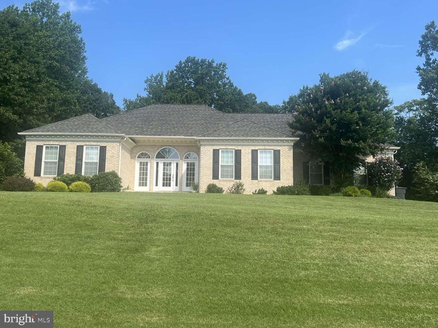 This beautiful white brick ranch home with a full basement, two-car garage and large asphalt parking area is a one-of-kind find in southern Maryland. Built by PF Summers in 2002, this home combines thoughtful, wood finishes, and quality craftsmanship in one of Calvert County’s most desirable communities. As you enter the home through its beautiful front porch, you will find an entryway and living room with 12 ft ceilings and crown moldings, a fire place and direct access to beautiful red cedar screened-in back porch overlooking a large back yard with an 8x8 paver fire pit. It could also fit a large deck and pool area. The living room also connects on one side to 3 bedrooms each with 1-2 large closets and full bath with a double vanity and separate enclosed toilet with large cabinet. On the other side, the living room connects to a beautiful dining room with crown moldings, wainscoting and baseboards, and a large kitchen with breakfast nook with views of the red cedar back porch and back yard. The kitchen features large wood cabinets and counter space areas for prepping/serving meals as well as an easy access pantry. The primary bedroom suite, laundry and garage are on this side of the home as well. The garage is a two-car side-load garage with its own large storage area as well as attic space access. The primary suite has views of the backyard and access to future external deck. The suite includes a large bathroom with white tiling, large jacuzzi tub, the walk-in shower with a glass door, spacious his and hers vanities, spacious walk-in closet, and an enclosed toilet with large cabinet. The primary bath is also connected to a separate room containing a washer and dryer, a laundry/utility sink, spacious linen closet and laundry shelving for convenience. The curb appeal shines with this white brick house sitting high on a beautiful 2-plus acre lot including spacious two-car side-load garage, huge asphalt parking area, matching brick mailbox and welcoming front porch. This home also has outstanding possibilities depending on your needs with its 2,626 sq ft walkout basement - ideal for in-law suite, theatre room, entertainment, extra bedrooms in the future or storage (already plumbed for two full baths, laundry room and kitchen and has a separate basement heating/cooling unit and ducting already installed). As a resident of Whispering Woods, you’ll enjoy access to community amenities including a tennis/basketball court and playground.