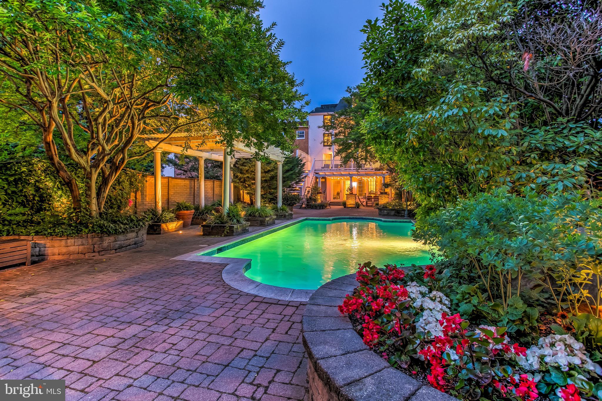 Like no other. Less than half a block from the dining, shopping and waterfront merriment of Thames Street, sits on the calm, tree canopied stretch of Bond Street, the most unexpected treasure of a Baltimore home.Stepping off the sidewalk, through the front door and into a welcoming foyer, one is immediately confronted by the home's layered charm and its understated elegance, a current taste flattering the details of centuries passed. French doors, cut into a wall of exposed two hundred year old brick, mark the transition between the 1860's 828 Bond and the conjoined 1780's 830 Bond. A formal living room sits just off the foyer and despite its immediate proximity to the rushing sidewalk, feels miles away from the excitement of outside. Its design exemplifies the home's aesthetic; craftsmanship of the past presented with the clean symmetry of today. Just beyond the living room, through the updated kitchen (another example of the modern and the timeless with its dark grouted geometric subway tile playing off the tin ceiling), one finds another rare gem: a large dining room, more like an urban ballroom. Nearly 500 square feet of hardwood floors and against a wall of windows, this space is an entertainer's dream and the possibilities for eventual kitchen expansion have endless potential. Through the dining windows is a view enjoyed by no one else this side of Guilford or Roland Park: the jaw dropping back patio and heated swimming pool. Occupying what feels like its own double lot, the back patio is a wonder of downtown living. Extensively hardscaped, the private outdoor space with its walled perimeter features tall trees stationed as cornered sentries. Parking for FOUR cars sits just outside the secure gate, just next to the gazebo. The seclusion is disorienting and the hurried momentum of the city quickly fades.What about upstairs? Coming across the second-floor landing, one passes a bedroom with private bath and enters into a generous den with several windows forming a tree-top triptych with sunlight pouring through the branches. A small stairwell leads to a wet bar complete with wine fridge and refrigerator; a second bedroom to the right and another full bath to the left. A door leads to a large, second floor deck that overlooks the pool. On the third floor, a stunning master suite. French doors open to a large sitting room with a gorgeous tray ceiling and woodburning fireplace. A large archway leads to the sleeping quarters, another woodburning fireplace sits at the foot of the bed, flanked by built-in bookcases and a balcony looks down upon the treetops of the back patio. Off of the sitting room, another small set of stairs leads down into a large dressing room (with laundry) and the breathtaking master bathroom a two story, marble-tiled masterpiece with soaking tub, dual vanities and an open shower. The fourth floor brings two more bedrooms and another updated bathroom, the roof lines and the window dormers create an eye pleasing geometry of modern lines and cozy nooks. The history of this place affirms its stately presence. The home of privateer captain Thomas Winning, 830 Bond Street was built in 1783 and gifted to his daughter shortly thereafter. Before the War of 1812, it became the home of Daniel James, the innkeeper of Thames Street. Over the following two hundred years, as it became combined with 828 Bond, taking on its address, evolving into its current grandeur, it has always been regarded as the finest house on the block.