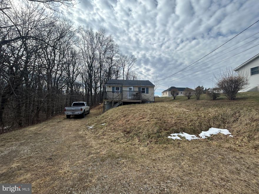 Discover the charm of this raised ranch nestled in the serene Hampstead community. This inviting 2-bedroom, 1-bathroom home boasts a perfect blend of comfort and functionality, ideal for those seeking a peaceful retreat. The eat-in kitchen with its built-in wood cabinets and appliances, is a culinary haven, while the entry-level bedroom offers convenience and accessibility. Outside, the property sits on a generous 0.53-acre lot, providing ample space for outdoor activities and relaxation. Enjoy the tranquility of nature as the backyard backs to lush trees, creating a private oasis for your enjoyment. The front and rear yards are perfect for gardening or simply soaking up the sun. A spacious deck invites you to unwind with a morning coffee or host summer barbecues under the stars. With convenient driveway parking and sidewalks for evening strolls, this home combines comfort with community. Don't miss the opportunity to make this residence that offers both serenity and accessibility your own!