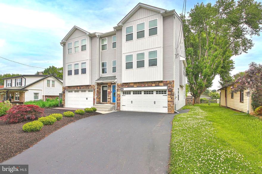 Welcome to 346 Roberts Ave in Conshohocken, located within the highly sought-after Colonial School District! This beautifully maintained twin home offers the perfect combination of modern style, spacious living, and everyday convenience with 3 bedrooms, 2 full baths, and 2 half baths. Thoughtfully updated and meticulously cared for, this move-in ready home offers stylish finishes, flexible living space, and an ideal layout for today’s lifestyle. Step inside to discover bright, open living spaces accented by gleaming hardwood floors and tasteful finishes throughout. The stunning kitchen serves as the heart of the home, featuring rich dark cabinetry, beautiful granite countertops, subway tile backsplash, recessed lighting, and stainless-steel appliances including a GE Profile refrigerator and Bosch dishwasher. The oversized center island with stylish pendant lighting offers additional seating and is enhanced by a custom extended end panel with a built-in wine fridge — perfect for entertaining and everyday functionality.
Flowing seamlessly from the kitchen is the spacious dining area, filled with natural light and ideal for gatherings large or small. The adjoining living room offers warmth and character with a dramatic floor-to-ceiling stone gas fireplace as its centerpiece. Sliding glass doors lead directly to the rear deck, creating the perfect indoor-outdoor flow for relaxing evenings or hosting guests. Completing the main level is a conveniently located powder room. Upstairs, the spacious primary suite provides a relaxing retreat with plush carpeting, abundant natural light, a large walk-in closet, and a beautifully appointed en-suite bath featuring dual vanities, generous storage, and a large glass-enclosed tiled shower. Two additional nicely sized bedrooms offer ample closet space and flexibility for family, guests, or a home office. A full hall bath with dual vanity and tiled tub/shower combination, along with a convenient second-floor laundry room, complete the upper level. The walk-out lower level provides exceptional additional living space ideal for a family room, media room, playroom, home office, gym, or guest area. Sliding glass doors offer direct access to the rear yard, while a newly added powder room completed in 2021 adds extra convenience. This level also provides interior access to the attached 2-car garage and additional storage space. Outdoor living continues with the expansive fenced-in rear yard (fence 2024), offering plenty of room for entertaining, pets, play, or gardening. Enjoy summer BBQs on the elevated rear deck or unwind on the covered paver patio below. Mature trees create a private and picturesque setting, making this outdoor space feel like your own personal retreat. Additional upgrades include new carpeting (2020), Nest thermostat (2021), central air UV light system (2022), Culligan tankless reverse osmosis drinking water system and Wi-Fi house water softener (2022), tinted front windows (2024), and a brand-new garage door with wireless access (2025). Offering convenient access to all that Conshohocken has to offer, including parks, shopping, vibrant dining and nightlife, King of Prussia, Plymouth Meeting, and Center City Philadelphia. Enjoy low-maintenance living with no HOA fees while being just minutes from local train stations, major highways, and popular area amenities. This is a wonderful opportunity to own a beautifully updated home in one of Montgomery County’s most desirable locations!