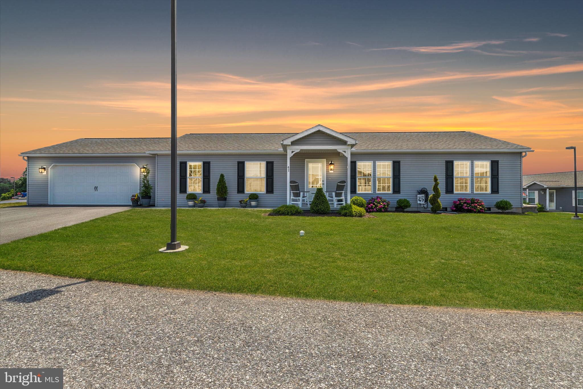 Wow! Exquisite 3 yr old Manufactured Home Now Available in the Desirable 55+ Community of Stoneyfield Estates! Nestled in the countryside of W. Nottingham Twp... yet close proximity to Rt 1, I-95, Maryland, DE and all shopping in Oxford, West Grove and Rising Sun! This Interior Decorator/Artist owned home shows better than a Model and has been gently lived in! Eye Catching Curb Appeal, Custom Exterior Light Fixtures , Landscaping, and Welcoming covered front porch! Enter into the sundrenched Living Rm with dove color carpet, flows to the huge gourmet Kitchen with Luxury Vinyl Plank Flooring, Gray Shaker Style Cabinets, soft close drawers, recessed Lighting, Pendant Lights over Beautiful Center Island with deep stainless Farm Sink, Essa pull down faucet, under counter microwave, Upgraded Optimum Whirlpool Stainless Steel Appliance Package, Z-Line Stainless Range Hood, Tiled Backsplash, Cresent Edge Counter Tops, a Large Walk In Pantry , Open Corner Shelving and a small workstation with Chalkboard wall. . Flows to the large Dining Area with sliders to the Rear Patio! The Primary Suite features a transom window on the far wall, Primary Bath with Double Bowl Vanity, 36" x 60" Dumawall PVC Tiled Shower w/ Dreamline Sapphire Doors, Water Closet and Walk In Closet! Down the hall to two additional good size bedrooms which share a second full hall bath! An optional "Preachers Bench" with overhead cabinetry, Laundry Rm with Sink and Additional added cabinetry. Mechanical Closet houses the HVAC Unit and New 40Gal Electric Hot Water Heater! Exit into the Stick Built Oversized Two Car Garage with Opener, Fully Drywalled w/ additional storage space and convenient Door to Backyard! This Premium Corner Lot offers Gorgeous Scenic Vistas overlooking Farmland and providing wonderful Sunsets. Well Positioned Planters with Trees and shrubs offering privacy and visual appeal while relaxing on the Large 12 x 16 Patio with Retractable Awning , pavers to a bonus Outdoor Shed and Bilco Doors to the crawlspace running the full length of the home! Lovely Stone Retaining Wall compliments the Level Backyard! Be prepared to be impressed by the Quality 2 x 6 Construction and attention to detail! This Modular Home is placed on a Permanent block and concrete foundation. Prospective Buyers must make application and receive approval from Martins Community Mgt upon acceptance of an offer to purchase. Land Lease is $530/mo plus an additional $40/mo Water Fee. This fee includes Community Sewer, Private Waste Water Treatment Facility, Trash, and Snow Removal on the Community Streets. An absolute Pleasure to show! Welcome Home!