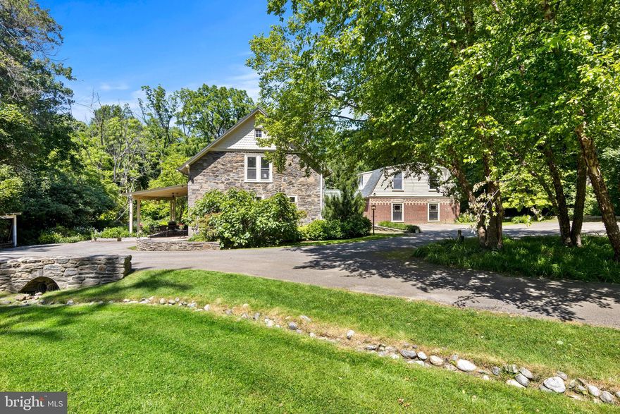 Welcome to the Westleigh carriage house & caretaker’s cottage, constructed in 1860 for Richard Vaux, the Mayor of Philadelphia from 1856 to 1858 amongst many other notable appointments & careers. The privacy that surrounds the property is amazing with a gently sloping front lawn. A spring fed chase flows across the lawn and under a lovely stone bridge. The property is enhanced with an EV charging station at the entry with parking for at least 5 cars plus a circular drive. Originally, there were two separate buildings. The carriage house & stable is a charming 2-story masonry building. The caretaker’s cottage is a detailed 2-story brick and cedar lap siding building. In 2009, the two structures were connected by an atrium that provides direct access from the front driveway. Entire walls of windows face both the front & rear yards with a wood floor that wraps around to the kitchen with an exposed stone wall. The floor plan of the building provides so many options for various private & public gatherings. So many enhancements have been completed just within the last 12 months! On the ground floor there are remnants of 3 straight stalls along the dining room wall. The stall windows retain their metal guards that kept the horses from breaking the glass. The kitchen was completely updated in 2023. The central island has a beautiful hardwood counter while the cabinets along the exterior walls have granite counters. The tiles selected for the backsplash are designed to resemble a tin ceiling! The entire appliance package is from the GE Café line in white, with a 6-burner, double oven range, dishwasher and French door refrigerator. The microwave is tucked into the large pantry closet. There is a powder room tucked off the kitchen & front entry door. The living room occupies the space where the carriage used to be stored. A full width glass door provides access to the side covered porch. The original carriage doors remain as yet another architectural element of the building’s past. A wood burning fireplace anchors the room flanked by built-in shelves & cabinets. The 2nd floor was completely renovated in 2023. The primary suite overlooks the rear yard (with 2 doors to a lovely small balcony) with 2 walk-in closets. The primary bath has an oversized glass enclosed shower, a free-standing tub, tiled flooring with radiant heating and an oversized vanity. The laundry room was moved to the 2nd floor. The 2nd bedroom on this floor has a wall of closets & its own ensuite bathroom with a tub/shower combination & storage closet. Enter the caretaker’s cottage, there is so much more to discover. The family room has a glass door that provides access to the 2nd floor. Beyond the family room is the 3rd bedroom with an ensuite bathroom with a stall shower. A walk-in closet has a window overlooking the side yard. The 2nd floor of the caretaker’s cottage provides multiple options for use. It is a legal one-bedroom apartment that has its own access directly from the rear yard or from within the house itself. A fully equipped kitchen & living area with a wall of built-in cabinets and bookshelves occupies half of the space, while the 4th bedroom & the 4th ensuite bath has its own stackable washer & dryer. Off the rear of the caretaker’s cottage is a full-width storage shed where a repurposed cabinet & a large workbench will remain with the property. A gently sloping rear yard with mature trees along the border is extremely private. A bank of daffodils provides a beautiful canvas in the early spring. Along the side of the carriage house, there is a pent roof & large patio that provides a shaded respite for outdoor entertaining and a formal perennial garden with pea gravel pathways. Come discover the Westleigh carriage house & caretaker's cottage, you too will be entranced by the privacy & personality of this truly unique residence.