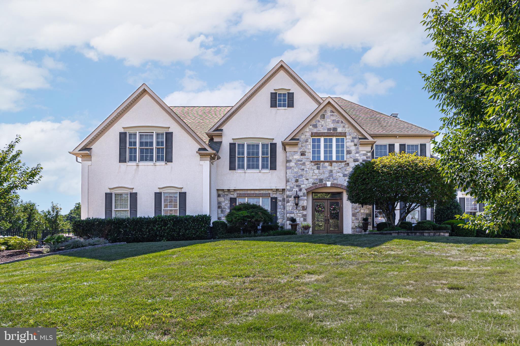 This exquisite 5-bedroom, 4.5-bath home is a true masterpiece of elegance and modern comfort. Situated on over an acre of property, you are greeted by professionally landscaped and hardscaped beauty in one of the most sought-after neighborhoods. As you step inside, you'll be captivated by the architectural design in the foyer, highlighted by the curves of the staircase and the stunning chandelier. The beauty of the hardwood floors flows throughout most of the main floor, with the warmth of carpet insets accentuating and defining the living and dining rooms. A solarium adjacent to the living room is the perfect place for drinks in front of the fire, game nights, a theater room, or anything you wish to create. The great room is a true focal point, adorned with majestic wood beams that accentuate the soaring ceilings, floor-to-ceiling stone details, and expansive windows that allow sunlight to seamlessly flow through. A sleek electric fireplace adds design and ambiance to this inviting gathering space, making it the ideal spot for family gatherings or entertaining guests. The heart of this home is undoubtedly the custom kitchen, where culinary dreams come true. Boasting top-of-the-line appliances, exquisite cabinetry, and luxurious countertops, this kitchen is a chef's paradise. Whether you're preparing a gourmet meal or hosting a casual brunch, there is both beauty and functionality. Step outside, and you'll discover an oasis of relaxation on the covered porch. These outdoor spaces are perfect for al fresco dining, lounging, or simply taking in the serene views of your beautifully landscaped surroundings. Multiple social spaces have been designed in the yard for relaxing in the hot tub, chatting around the firepit, or reading a great book while enjoying the privacy and beauty.
The opulence of this home doesn't end there. A finished basement with a full bath awaits your indulgence, complete with a wet bar for entertaining and a full gym for maintaining an active lifestyle. Whether you're watching the big game, mixing cocktails with friends, or working up a sweat, this lower level offers endless possibilities for enjoyment. With 5 spacious bedrooms and 4.5 bathrooms, including a master suite that exudes luxury and comfort, this home provides a retreat for every member of the family. The master bath boasts a soaking tub and glass-enclosed shower, ensuring you can relax and rejuvenate in style.
In the sought-after Ridings of Warwick, you'll enjoy a lifestyle of exclusivity, privacy, and convenience. This home is not just a residence; it's a statement of success, a sanctuary of style, and a haven of comfort. Experience luxury living in this breathtaking property, located within minutes of restaurants, shopping, major roadways, and the National Award-Winning Central Bucks School District.