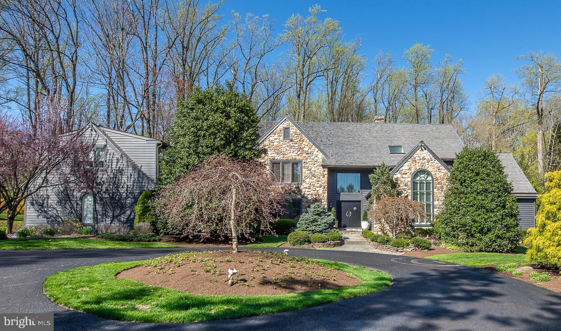 This elegant Belber built custom home, designed by Ann Capron, is like no other, with 14, 17 & 18 ft. cathedral and beamed ceilings, generously sized rooms, many with full walls of windows offering wonderful natural light. The location is ideal, with lush landscaping, shrubbery & flowering plants offering an abundance of privacy. This quiet cul-de-sac neighborhood is in the heart of Chester County close to upscale Shopping and Dining, Great Schools, Transportation and more. The inviting flagstone walkway leads to the double French door entry. Once inside, the impressive two story 17 ft. Entry Foyer offers front-to-back views of the step down Living Room with 18 ft. ceiling, gas fireplace and a wall of windows facing the tranquil pool and deck lounge area. The first floor Study with 14 ft. cathedral ceiling is conveniently located right off the Foyer along with a double door closet and Full Hall Bathroom which could easily become an additional first floor Bedroom Suite, if needed. The fabulous first floor Primary Bedroom Suite features a luxurious spa style en-suite Bathroom, with radiant heated marble floor, soaking tub, frameless marble shower and glass slider to the Pool Deck. There are two separate vanities, toilet rooms and dressing areas with custom walk-in closets. The Formal Dining Room is to the left of the Foyer and flows into the custom French Country Gourmet Kitchen which is well equipped with high end appliances (Sub-Zero refrigerator, Thermador commercial style 6-burner gas range with a double oven, and Thermador dishwasher), marble countertops, beamed ceiling a perfect setting for the discerning chef. Enjoy informal meals by the double side fireplace in the generous Breakfast Room with 14 ft. arched beamed ceiling, then relax with your coffee in the bright Family Room and take in the sights of the pool and scenery. There is great flow between the rooms and also easy indoor/outdoor access for all your entertaining needs. The second floor features the 2nd and 3rd Bedrooms along with a Full Hall Bathroom, a second home office, 4th Bedroom, Full Hall Bathroom, and a spectacular Great Room with three walls of windows, a gas fireplace, a media/entertainment center, exercise area, closet storage and 5th Full Bathroom. The finished Lower Level features knotty pine beadboard, barn doors, custom bar, wine cellar, media/billiard room, work room, and ample storage rooms. The fabulous outdoor living spaces will entice you with a comfortable sitting area with an awning for shade, a gorgeous in-ground swimming pool, with ultimate privacy and is easily accessed from Family Room, Breakfast Room, Living Room and Primary Bathroom. This is a one of a kind home with so many exceptional features – you just have to see it in person!