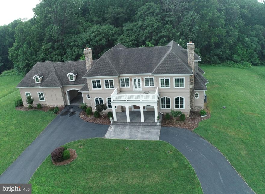 This beautufully designed French Colonial is nestled in serene farmland. You will not find a better, well built home in Harford County. A circular drive leads to the covered front porch with balcony above. Custom Anderson windows, 3/4 inch quarter sawn hardwood floors, spectacular millwork, french doors across the rear of the home open to patios on both the main and lower level.  Main floor office is sizeable and currently employed as an additional sitting room. The gourmet kitchen with Viking stainless appliances has ample spaces for cooking,  food prep, clean-up & entertaining. The large central island includes 1 of 2 full size sinks, 2 full size dishwashers and provides views to the rest of this gracious home. The eat-in dining area is large enough for a table seating 8-10 guests and adjacent french doors open to the patio. The Central main room of the home, family lounge area with gas fireplace has also been used as an elegant dining room. Two sets of French doors to the back patio provide excellent flow while entertaining. Both the Central main room and large Great room feature gas fireplaces with custom mantles. The Great Room has space for dining (or a pool table), lounging in front of the fireplace flanked by soaring 2 story windows, and a wet bar with wine fridge framed beautifully by bay windows. One of 2 main floor powder rooms are located here. Two staircases lead to the 5 bedrooms & 4 full baths upstairs. The generous primary bedroom & bath enjoy views of the surrounding farmland with access to the front catwalk and balcony. The primary bath includes 2 sinks, large soaking tub, custom shower with dual shower heads, water closet & large linen closet. Bedroom 2 has it's own ensuite & access to the catwalk & balcony. Bedrooms 3&4 share a jack and jill bath each with it's own powder room.  Bedroom 5 is a large Guest Suite that boasts it's own hvac zone, hotwater heater & private staircase to the garage. The 3 car garage with vaulted ceilings opens to the rear of the home with ample space for parking  & shooting some hoops.  Awaiting your personal touch, the unfinished Lower Level was designed to accomodate high ceilings. Lower level windows & French doors to the patio bring in the natural light. With almost 4 acres of property there is room to expand the already generous outdoor living space. This home combines the privacy of a pastoral setting with the convenience of shopping & restuarants just minutes from home.