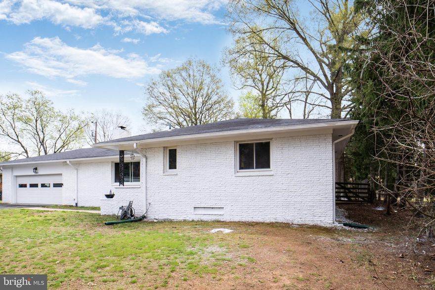 Welcome to 12323 Lanham Severn Road, Bowie, MD. This 100% bricked, raised ranch with fully finished basement and bountiful back yard offers the perfect blend of character, comfort, and outdoor connection. Located on a beautifully treed lot of nearly an acre (.83), indoor and outdoor jewels abound in this 3,324 sq. ft. haven.


This elegant white brick home sits back from the street behind large formosas and an ample front yard. The beautiful façade sets the tone for the home’s interior. The foyer features hand selected, neutral-toned stone flooring and an octagon-shaped window. The large family room is bathed in natural light from a large picture window and features a half brick wall and wood burning fireplace with stove. Honey-colored hardwood floors flow through the main floor.

 

The kitchen features stainless steel appliances including a freestanding electric double oven range, French door refrigerator with dual ice makers, and dishwasher. The eat-in kitchen includes a peninsula, a stainless-steel pully light fixture (the retail last of its kind, shipped from California), and room for a desk if you like. A patio door in the eating area leads to the outdoor oasis.

 

The primary suite is large enough for a king-sized bed with room to spare. Behind a pocket door you will find a tiled bathroom with shower and another pocket door to the bathroom closet. Bedroom #2 has been converted to a “closet-room” through French doors adjoining the primary suite and can easily be converted back to a bedroom. Bedroom #3 is also found on this main level. A hall bathroom features a generous linen closet. Rounding out the main floor is bright laundry room with washer, dryer, utility sink, and vinyl coin flooring. Doing laundry will never be dull again.

 
A door from the kitchen area leads to the two-car garage. The garage features open rafters and hanging storage platforms, a custom-built workman’s bench and a second gardening bench. A front double garage door and a back single garage door with separate garage door openers, allow for driving through the garage itself.


Behind a pocket door and down the stairs, the lower level serves as a personal lair for a “work hard, play hard” lifestyle. It features an ample office (with storage closet and window) that has also served as a fourth bedroom in the past. A half bath is also on this level.

 

The back area with black walls & ceiling is staged as a theater room with an encased 73” TV and four theater chairs, all which convey. The front area features a second, fire-red painted fireplace, room for seating, a mounted TV, and a grey billiards table with ball return that convey. These two areas have hosted many family gatherings, fight parties, game & movie nights, & get-togethers. Craving peace & quiet? Escape to the lower level, dim the lights, recline the theater chairs and fall asleep watching a movie you have seen so many times you know most of the dialogue.

 

The big backyard has hosted many barbeques, tented parties and baseball games. Pick one of the sunny spots for gardening or think about installing a pool. Store your tools and toys in the substantial shed.


In 2013 approximately 80% of this home was re-constructed down to the studs including the rafters & roof. Four bracketed TV’s; one 73” TV; pool table; and snow blower convey.  Words can’t truly describe this well-maintained home. Schedule your must-see tour today! Seller's Concession available!