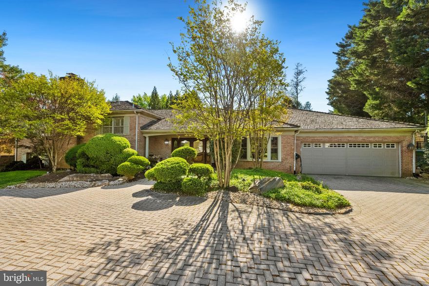 Celebrated for its stately architecture and timeless appeal, Evermay is one of McLean’s most coveted communities, admired for its generous homesites, manicured landscaping, and pedestrian-friendly tree-lined sidewalks. This distinguished split-level residence offers a rare opportunity to reimagine a classic home on an expansive lot, showcasing a four-side brick exterior, a sweeping semi-circular brick driveway, and beautifully maintained gardens. A slate-covered front porch and custom solid wood double doors welcome you into a spacious foyer with natural stone flooring, setting the stage for the elegant interiors. Designed for both refined entertaining and comfortable daily living, the home features expansive, sunlit spaces. The formal living room includes a handsome brick wood-burning fireplace and oversized sliding glass doors that open to the serene rear grounds. Rich oak parquet-style hardwood flooring and crown molding flow into the formal dining room, framed by a charming bay window. The chef’s kitchen is equipped with solid wood cabinetry, granite countertops, and stainless-steel appliances, including a 48” professional-grade KitchenAid refrigerator. A peninsula with breakfast bar seating overlooks the inviting family room with vaulted ceilings, a dramatic brick fireplace wall, and oversized sliding doors showcasing views of the koi pond and waterfall. A convenient powder room and laundry/mudroom with garage access complete the main level. Up just half a flight, the sunlit upper hall features hardwood floors and a skylight. The primary suite offers crown molding, plantation shutters, a walk-in closet, and a spacious ensuite bath with dual vanities, soaking tub, walk-in shower with bench, and ample cabinetry. Two additional bedrooms share a buddy bath with double vanity and combined tub/shower. The lower level includes a generous recreation room with parquet-style oak hardwood flooring and a third brick fireplace. A vintage-style wet bar with seating makes entertaining easy, while two more bedrooms, one ideal as an office, share a large buddy bath. Outdoors, the home becomes a private sanctuary. A sprawling slate patio with multiple seating areas overlooks the lush backyard, highlighted by a koi pond with cascading waterfall and an oversized hot tub. Stepping-stone paths wind through the fully fenced, professionally landscaped gardens. Just minutes from Tysons Corner's world-class shopping, dining, and entertainment, the home also offers effortless access to Georgetown Pike, GW Parkway, I-495, I-66, the Dulles Toll Road, the Silver Line Metro, and Washington, D.C. Nature lovers will appreciate nearby access to a 150-acre wooded preserve with scenic trails and Clemyjontri Park, a beloved local playground just three minutes away. Franklin Sherman Elementary, Longfellow Middle, and McLean High School.