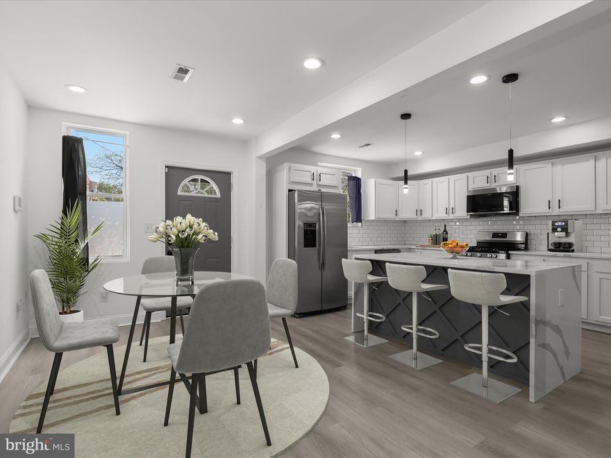 This beautifully renovated 4-bedroom, 3-bath rowhome blends modern style with everyday comfort. A covered front porch welcomes you into a thoughtfully updated interior featuring an open floor plan, luxury vinyl plank flooring, and a fresh neutral color palette.  The main level offers a spacious living room with recessed lighting and a decorative grid-panel accent wall, flowing seamlessly into the dining area. From here, step out to a private rear courtyard—ideal for outdoor dining or relaxing in warmer months.
The updated eat-in kitchen stands out with white cabinetry, stainless steel appliances, quartz countertops, and a classic subway tile backsplash. A center island with waterfall-edge countertop and seating adds both function and style.  Upstairs, the primary suite includes a full bath with a tiled tub/shower combo and a separate walk-in shower. Two additional bedrooms, a second full bath, and a laundry hookup add convenience.  The finished lower level offers a versatile recreation room, a fourth bedroom, and a third full bath—perfect for guests or extra living space.  With easy access to public transportation, I-95, and I-695, this move-in ready home offers excellent value with its quality upgrades and ideal location.

Note:  Select interior photos have been virtually staged