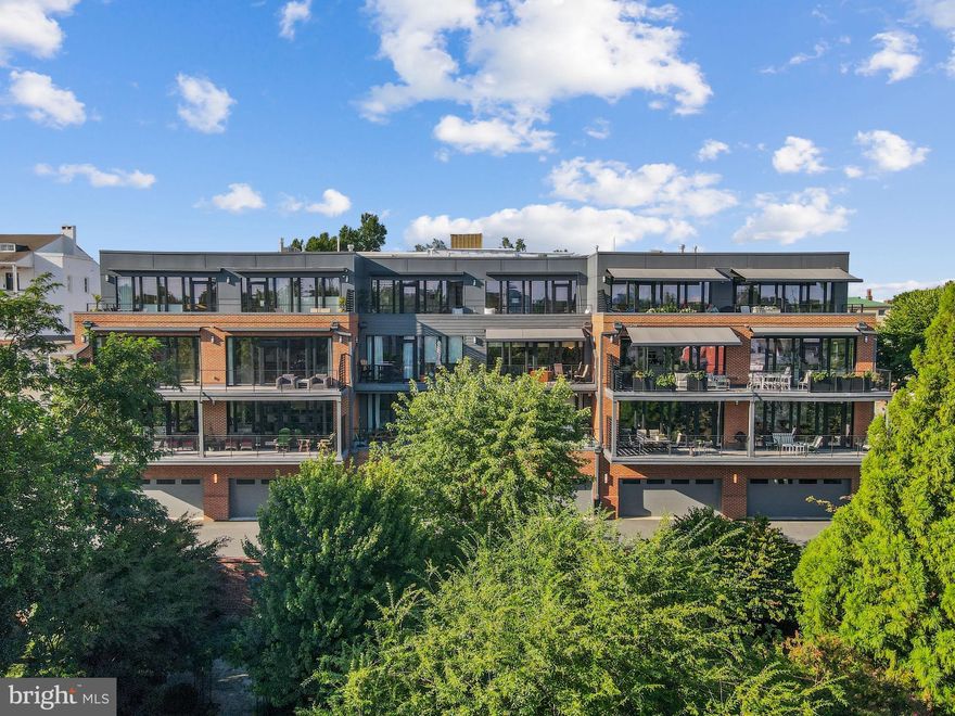 A rare offering in the heart of Downtown Frederick, this newly built 2023 residence redefines modern luxury while embracing the charm and character of its historic surroundings. Elevated above the city, it offers a quiet and private sanctuary just steps from award-winning dining, boutiques, and cultural landmarks—perfect for those who desire the best of both worlds: serene retreat and vibrant urban lifestyle. With convenient access to Washington, D.C. and Baltimore, this home is also an ideal escape from the city, offering low-maintenance luxury living with effortless commutability.
This exceptional home features two spacious bedrooms plus a den—ideal for a home office or flexible space. The open-concept living room, dining area, and kitchen are framed by windows spanning the entire unit, flooding the home with natural light, merging the indoors with the outdoors. The primary suite rivals that of a luxury hotel, with a beautiful en-suite bathroom and direct access to the patio.
From the moment you arrive, the differences are clear. Beyond the standard new-construction finishes, the sellers have invested in thoughtful, post-construction enhancements designed for both elegance and convenience. The expansive patio—already a rarity in downtown living—has been elevated with automatic awnings and retractable drop screens, allowing you to block the sun, create shade, or enjoy complete privacy at the touch of a button. Set at the back of the building, the terrace overlooks Frederick’s historic skyline while being thoughtfully recessed, ensuring no one below can see onto the patio. This is an outdoor space designed as a true extension of the home—a hidden jewel for quiet mornings, private entertaining, or sunset views over the city.
Inside, the upgrades continue. A built-in speaker system delivers seamless, whole-house entertainment, while a state-of-the-art security system with keyless entry provides both modern convenience and peace of mind. The kitchen is a chef’s delight, appointed with luxury Cafe-brand appliances that blend striking design with top-tier performance. Every element has been selected to elevate daily living into something exceptional.
The convenience of an oversized, private two-car garage—a rarity in downtown Frederick—adds unmatched value, ensuring both secure parking and abundant storage.
Designed for those who value privacy without sacrificing connection, this condominium is the perfect balance of low-maintenance luxury and city access. With all furnishings and décor negotiable, it is offered as a turnkey opportunity to embrace a lifestyle defined by elegance, ease, and distinction.