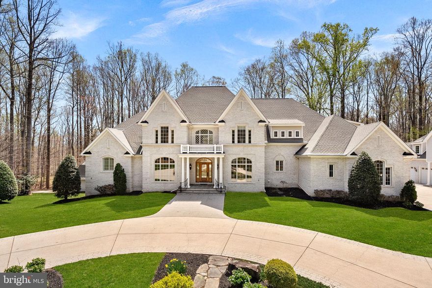 Set on five private acres along Chapel Road, this custom-built estate sits quietly back from the road, with a presence that’s often noticed in passing and remembered.

Designed with longevity in mind, the home offers over 11,000 square feet that lives with an ease rarely found at this scale. Spaces are thoughtfully proportioned and connected, allowing for both everyday comfort and larger gatherings without ever feeling overwhelming.

Built with enduring materials throughout, the residence features four-sided calcite brick construction, solid wood doors, custom millwork, oak flooring, and architectural detailing that reflects a more timeless approach to design. A library with custom floor-to-ceiling cherry built-ins and multiple French doors adds warmth and continuity across the main level, while the kitchen is supported by a well-appointed butler’s pantry with additional freezer and dishwasher—allowing function to exist without competing with form.

A gated arrival and circular driveway set the tone. As you approach, arched windows with beveled glass, caming, and cast stone detailing begin to reveal the level of craftsmanship carried throughout the home. The covered entrance, framed by gracefully curved wrought iron railings and a richly finished hardwood door, creates a sense of arrival that is understated and unmistakable.

The home was designed to support long-term, effortless living across all three levels, including elevator access—an expected feature for a residence of this scale. A main-level primary suite, four upper-level ensuite bedrooms, each with generous walk-in closets, and flexible living spaces throughout offer the ability to accommodate a range of lifestyles, including multi-generational living.

The walk-out lower level extends the home naturally, anchored by a substantial bar, multiple gathering areas, and direct access to the rear grounds. Outdoor living is equally considered, with an expansive IPE hardwood deck overlooking the south-facing yard, framed by mature trees and a setting that offers both openness and privacy.

A detached carriage house provides additional flexibility with four garage bays, four lifts, finished upper-level space, and dedicated utilities—ideal for a collector, workspace, or extended use.

Homes of this caliber—where material selection, craftsmanship, and proportion take precedence over trend—are increasingly rare.