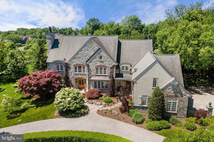 Stunning, custom-built residence designed by Rene Hoffman, located in the highly sought-after community of Evans Meadows in Lower Gwynedd.  The versatile floor plan is perfect for multi-generational living with an elevator to all 3 levels and a spacious finished lower level with private access. 
When entering the neighborhood, you will immediately notice the wonderful curb appeal with the Belgian block curbs and tree-lined street. The community provides open space and walking trails. This exquisite home is located in a tranquil setting with gorgeous hardscaping and landscaping with extensive lighting, irrigation system with 20 zones and specimen trees. The majestic backyard is a resort-like setting with a saltwater heated pool with spa and a waterfall feature. A circular driveway leads to a handsome full depth stone façade, adorned by mature landscaping. The custom Alder Wood front door invites you into the expansive 2-story foyer with amazing natural light and gorgeous walnut hardwood flooring. The foyer is flanked by a formal living room with a gas fireplace and a formal dining room with adjacent Butler’s pantry with a wet bar.
The gourmet kitchen features a six-burner gas range with a hood vent, Dacor double ovens, warming drawer, Sub-Zero refrigerator/freezer, large island with granite countertops. A cheerful breakfast room provides access to the covered patio area and a lovely sunken family room is located adjacent to the kitchen with a gas fireplace, built-ins and incredible views of the backyard from the soaring windows. The main level of the home also offers 2 offices. One with wormy chestnut built-ins and access to the covered patio. The second office is tucked away at the far end of the home with plenty of natural light and built-ins.  There are 2 powder rooms available for guests.  A spacious 3-car garage. Head to the upper level from one of two staircases or the elevator, that takes you to all 3 levels of the home.
 
The primary bedroom suite has a cathedral ceiling, magnificent natural light, two large walk-in closets with custom built-ins, a morning coffee bar and a sumptuous bathroom with a soaking tub, dual vanity, stall shower and a private water closet. There are four additional spacious rooms on the upper level. One is en suite bedroom and two additional bedrooms share a Jack and Jill bathroom.   The expansive bonus room/5th bedroom includes roughed-in plumbing for a full bathroom and a conveniently located laundry room with a sink. Pull-down access to a floored attic with full ceiling height offers great storage and an opportunity for additional future living space.  
 
The finished lower level with daylight windows boasts a fantastic temperature-controlled wine cellar for 775 bottles, a large recreation room, a wet bar, billiards room, a full bathroom with steam shower and incredible storage. There is secondary access to the 3-car garage from the lower level.  This is a great space for an in-law/au pair suite or guests.  The owners spared no expense when building this home. Pella architectural series windows, Certain Teed Independence 50-year roof, standing seam copper roofs with copper flashing, downspouts, sound system throughout many rooms in the home, ‘whole house generator’ and more! See agent for full list of features.  Choose from the award-winning Wissahickon School District and various nearby options for renowned private schools, such as Germantown Academy.  Fabulous location just minutes from shopping, restaurants, Gwynedd Valley train station and all major transportation routes, such as 202, 73, 63 and nearby access to PA Turnpike, 276, 76 and 476. Nearby Wings Field for aviation travel.  Enjoy nearby Ambler, Blue Bell and Spring House.  A short drive to the Plymouth Meeting and King of Prussia Mall.  A variety of options for golf courses and country clubs.