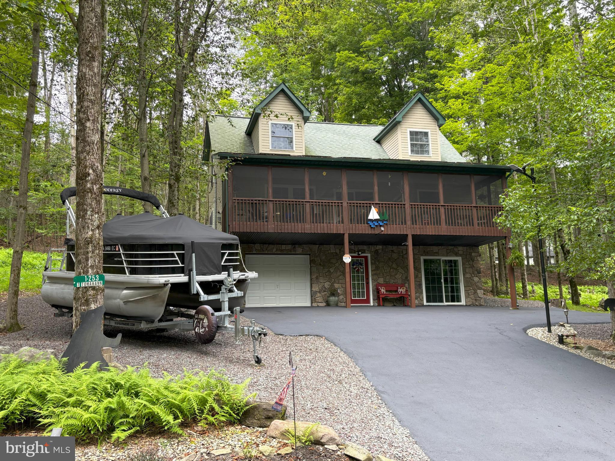 Elevated and turnkey, this fully furnished home offers exceptional comfort and utility with a host of premium features. Enjoy an extra-large screened-in porch, ideal for private lazy mornings with coffee or lively evening gatherings protected from the elements. The paved blacktop driveway includes generous extra parking and boat storage, leading to an attached 1-car garage with space for a workshop. Inside, luxury vinyl plank flooring flows throughout, complemented by Pella tilt-in windows for easy maintenance. The backyard showcases native ferns, a cozy firepit, and an outdoor grill connected to the main-house propane tank (owned)—never run out of fuel during a backyard BBQ. The home is equipped with a Navien tankless water heater plus a 50-gallon backup unit, and four heating options: a heat pump, gas furnace, electric baseboard heat, and a Wi-Fi-controlled fireplace that operates independently of electricity. Solar panels provide energy efficiency with a simple switch to return to grid power. You’re not just buying an exceptional home; you’re treating yourself to a resort-like lifestyle. Enjoy all the amenities the Wallenpaupack Lake Estates community has to offer. You have privileges to access 2 private lakes, beaches, 2 outdoor pools, an indoor pool & gym, dog park, lodges & game room as well as access to the private community marina on the big lake, Lake Wallenpaupack! The community dues cover the water, sewer and trash bills too! Showings begin Saturday, August 2nd.