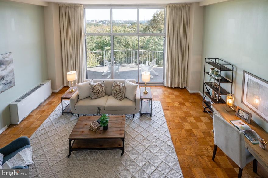 Renovated mid-century modern condo in the heart of Rosslyn with stunning monument/city views and two indoor parking spaces. The Prospect House, designed by architect Donald Hudson Drayer, is featured in James Goode’s seminal book on DC’s “Best Addresses” and offers ground-breaking modernist design with captivating views of Washington and prime, convenient location. The 2 bed/2 bath 1,398-square-foot airy and light-filled space features dramatic living room with 13-foot ceilings and full wall of glass looking out to the expansive private balcony and those monument views. The Prospect House is not your standard vanilla condo. From the folded-plate porte-cochère to the preserved mid-century lobby, the building would feel at home in Los Angeles or Palm Springs. One of the unique designs of the building is that the units are open on both sides (east and west exposure) to let air and light flow through.
The design of the unit places the entrance on the 5th floor with an entranceway and sizable closet. Steps then drop down to reveal the soaring living room and view out the wall of glass and huge walls to display your modern art. The living room and dining room have original parquet floors and the renovated kitchen and bathrooms are clad in ceramic tile. The high-end open kitchen features extensive storage and stainless-steel appliances. The renovated hall bathroom has a soaking tub while the primary ensuite bathroom has a glass-enclosed shower clad with ceramic and glass tile and sitting bench. In addition to the renovated bathrooms and kitchen, all the glass and HVAC convectors have been updated.  
The monthly condo fee covers all utilities, heated outdoor pool, exercise room and 24-hour reception/security, storage as well as trash, snow removal, landscaping and all exterior maintenance, among other items. The on-site convenience store and cleaners add to the easy lifestyle.
Perched on a hill on a direct axis with the National Mall and just above the Iwo Jima Memorial and Netherlands Carillion, the Prospect House is just minutes to the Rosslyn Metro, the shopping and restaurants in Clarendon, National Airport, Georgetown, Rock Creek Park and Foggy Bottom.
