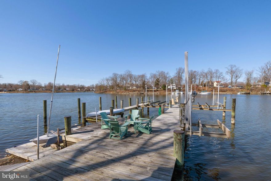 Absolutely stunning waterfront property located on Glebe Creek at the mouth of the infamous South River offering deep water, nautical charm and a delightful entertaining venue all within an easy commute to DC, Northern Virginia and Downtown Annapolis. Enjoy gorgeous 180-degree panoramic water views from this magnificent 3600 sf home offering 4 bedrooms, 3 full baths, private pier with multiple deepwater slips, boat house and 339' feet of water frontage on .59 acres. Enjoy expansive views from the walls of glass in the Great Room and the Primary Suite with adjoining Primary Bath to the newly designed and built, custom two-sided Fireplace. Offering gorgeous stonework, stone mantle and unique, see thru two-sided glass doors. It features dual access to the firebox from both the interior of the home and from the exterior deck. Tall windows positioned on either side of the fireplace expand the view further enhancing the waterside beauty with views of the water, deck and boat house. The deck area has new, high performance composite decking and is large enough to host either large waterside cookouts or small intimate get togethers. From the deck you can see to the South River or exit down steps waterside to the Boat House and Pier. Additional upgrades include a new roof, new skylights, new heat pump for bedroom level zone, hardwood floors thru out and all 3 bathrooms totally renovated. The Primary Suite has tall ceilings, big water views, and new custom walk-in closet cabinetry that then leads to a gorgeous bath with glass shower and a beautiful one of a kind vanity accent wall and of course... more water views! The bedroom level has 2 additional spacious bedrooms and upper level laundry area. The Main Level has the 4th BR/Office with beautiful terra cotta tile flooring, included Murphy Bed and newly renovated adjoining  full bath with bonus walk-in storage closet.  The Kitchen and Dining Room are on the same level as the 4th BR/Office and you step down to an expansive living area with huge deck space and water views wherever you look. Boaters will love the ability to have several boats and/or greet incoming boating friends offering multiple slips with 2-Hi N Dry 10,000 lb Boat Lifts and a Tide Tamer Industries Aluminum Swinger Boat Lift rated at 1500 pounds used for a small boat or jet ski + a floating pier. The Boat House is a party waiting to happen with Tiki Bar, refrigerator, table & chairs and running water and electric. There is also a pottery shed on the property with heat, A/C and electric that is presently being used as a kid's crash pad and could possibly be expanded to a larger structure under the newly passed AA County Accessory Dwelling Units Law (ADU's) permitting second, smaller homes which could be used for short term rentals such as Airbnb or VRBO if the new owner occupies the property.  Lots of wonderful possibilities here! In addition to all these features this home has a high and dry concrete floored basement accessed from outside that is outfitted with built-in workbenches and metal storage cabinets and tons of storage. Boaters will appreciate the 2 exterior storage lockers tucked under the deck great for storing swimming and boating gear. The surrounding community of Glebe Heights has a voluntary HOA fee and offers a beach, boat ramp, boat slips, and kayak racks. Close by is an AA County dog park. This home is public sewer, private water, dual zone heating and air, has an Invisible Fence and a newly installed state of the art home security system you can control with an app on your phone. This home will not disappoint!