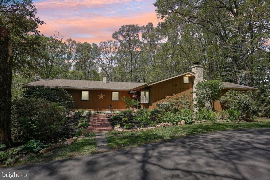 Welcome home to 396 Porters Mill Road—a secluded, custom contemporary ranch nestled on over 3 wooded acres in the scenic South Coventry countryside, within the award-winning Owen J. Roberts School District. Tucked back along a private driveway, this thoughtfully updated home offers the perfect blend of modern comfort and natural beauty. A charming courtyard with seasonal blooms and a brick walkway welcomes you into the open-concept layout, designed for both everyday living and elegant entertaining. The handcrafted kitchen features solid cherry cabinetry, granite countertops, stainless-steel appliances, and a striking floor-to-ceiling brick fireplace with a freestanding wood stove—creating a warm, inviting space that flows seamlessly into the great room with soaring cathedral ceilings, walls of windows, and peaceful views of the surrounding landscape. The home offers five bedrooms, including two with private en-suite baths for added flexibility and privacy. One of the bedrooms is currently being used as a dedicated office space, complete with beautiful French doors—perfect for working from home or enjoying a quiet retreat. The updated hall bath features marble flooring and a jetted tub, bringing a touch of spa-like luxury. The dining area and great room feature a third working wood-burning fireplace, adding warmth and character to your gatherings. Step outside to your personal retreat with a wraparound deck, lower-level patio, hot tub, fire pit, hammock, and an above-ground pool—plus a very large fenced-in yard, ideal for pets, play, and outdoor enjoyment. The rustic finished lower level offers a spacious walkout family room with a wood-burning fireplace insert, powder room, and sliding doors that lead directly to the patio and outdoor living spaces. Additional highlights include hardwood floors throughout, custom stained-glass accents, new roof (2019), new furnace, heat pump, new water heater 2020 and UV water filtration system 2022.—plus a location just minutes from schools, major routes, and local amenities. This unique property offers peaceful seclusion without sacrificing convenience—a perfect place to embrace nature, unwind, and create lasting memories. Public records is 400 Porters Mill, Postal Address is 396 - Tax ID 20-04-0084 (3.4 acres with dwelling)& Tax ID 20-04-0082 (1.2 wooded, landlocked acres).