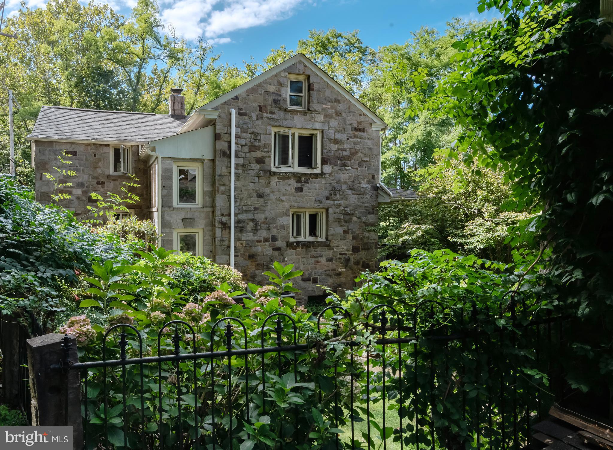 Nestled in the bucolic village of Lumberville sits a charming home with commanding views of the Delaware River. Once owned by three generations of Italian stone artisans, this one-of-a kind property with its unique architectural elements and stylish aesthetic, will simply captivate you. Iron fencing with stone posts and an inviting portico lead to the front entrance. As you enter, an exquisite stone fireplace with its intricate carved details including opposing griffins and floral embellishments, takes center stage. Beautiful wood floors lead to the open living space with paneled walls and an expansive picture window showcasing stunning river views. Another wood-burning stone fireplace, thoughtfully designed and executed with symmetry and precision, takes its prominent position in the living room. The dining area is open to the living space and leads to the kitchen. An unexpected nook for collectibles, silver and glassware is a sweet surprise. The kitchen has a vintage vibe, and features a stainless-steel double basin countertop sink, wood block and tile counters, open shelving and breakfast room. The upper level includes a primary bedroom with vaulted ceiling, walk-in closet, wood floors, deep window sills and an antique cabinet for linen storage. The primary bathroom is new and has a stall shower, subway tile and linen storage. Two more spacious bedrooms and one hall bath complete the second floor. In the basement you will find multiple rooms with options for a wine cellar, workshop, additional storage and laundry. Upgraded utilities include a Bosch Propane multi-zone heating system, and two Bryant AC systems (in basement and attic). Step out the back for panoramic water views and a front row seat to natural wonders each day. The spacious covered porch is the ideal spot for outdoor dining and entertaining. Complete with stone flooring and bluestone surround, the porch leads to the rear yard where you will pass a stone-carved sink, one of the many unique signature statements of the former property owner’s creative legacy. The lower terrace affectionately called “the ruin” creates a stunning perch upon which to soak in the expansive river view. The additional structure on the south-end is certain to capture your imagination. With its tempting river view from a Juliet balcony, brick walls and solid wood floors, this stand-alone structure has potential for a studio or office. One floor beneath is the former stone carving workshop with a fireplace and access to the rear yard. The two car garage on the north-end has two deep stalls and room for storage on the first level. For the outdoor enthusiast, the upper level offers additional storage capacity for recreational equipment, accessories and river toys. You will love the close proximity to the Delaware Canal towpath, local culture, first class dining and the Lumberville general store! This home is a testament to the artisan’s quality craftsmanship and impressive signature style. Before long, you could be the next steward of this intriguing property and own a rare piece of Lumberville history!