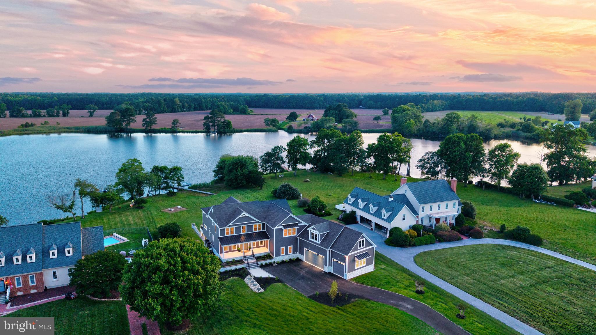 Welcome to Creek's Crown Estate at 11010 Trappe Creek Dr—an extraordinary waterfront sanctuary nestled within a tranquil community just minutes from charming downtown Berlin and a leisurely drive to Ocean City's pristine shores. This meticulously remodeled, three-level luxury residence encompasses over 8,000 square feet of sophisticated living, showcasing breathtaking panoramic water views and exclusive access to your own private dock. With Worcester County's approval already secured for pool installation, this estate offers limitless potential for creating your ultimate waterfront paradise.
The main level captivates with floor-to-ceiling windows that bathe living spaces in abundant natural light while framing the mesmerizing waterfront panorama. The gourmet kitchen stands as an entertainer's masterpiece, boasting a commanding center island, premium Sub Zero and GE appliances, an oversized walk-in pantry and laundry equipped with front load washer and dryer, and intelligent lighting that adapts to every occasion. The inviting living room beckons with its contemporary linear fireplace, creating seamless transitions to expansive outdoor entertaining areas. A thoughtfully positioned main-level guest suite provides unmatched privacy and convenience, complete with a generous walk-in closet, dedicated storage, and private deck access revealing spectacular water vistas. The main level's recreation wing showcases a spacious entertainment area flowing directly into the three-car garage, complemented by an impressive theater and golf/skeet simulator featuring a massive projection screen—transforming ordinary evenings into extraordinary experiences whether hosting movie nights, cheering your favorite team, or perfecting your swing and shooting precision.
Ascending to the upper level reveals a private haven where every bedroom enjoys its own luxurious ensuite bathroom, ensuring uncompromised comfort and privacy. The opulent primary suite serves as your personal waterfront retreat, featuring a private deck overlooking serene waters, an elegant sitting area perfect for morning coffee or evening reflections, sophisticated dual vanities, an expansive walk-in closet, and a convenient second laundry area. Abundant unfinished storage space provides endless customization possibilities. Among the additional upper-level suites, one stunning room offers deck access and showcases a spa-inspired ensuite sanctuary with an oversized walk-in shower, a soaking tub positioned to capture breathtaking water views, a spacious walk-in closet, and luxurious radiant heated tile flooring that transforms every step into pure indulgence.
The impeccably finished lower level presents remarkable versatility, featuring a complete bathroom, a fully equipped kitchenette with refrigerator, microwave, sink, and dishwasher, plus seamless access through sliding glass doors to a welcoming covered patio. This adaptable space effortlessly accommodates 1-2 additional bedrooms or can be reimagined as flexible living areas to suit your lifestyle. A secure vault provides ultimate peace of mind for your most valuable possessions.
Cutting-edge technology enhances every aspect of daily living with robust 600-amp electrical service ensuring unlimited power capacity, while the sophisticated WiFi-enabled smart home system provides intuitive control over sound, automated window coverings, and climate throughout the entire estate.
Creek's Crown Estate represents an unparalleled fusion of privacy, refinement, and waterfront elegance. Whether you're savoring peaceful moments on your private dock, hosting memorable gatherings on expansive decks, or rejuvenating in spa-caliber bathrooms, every exquisite detail has been masterfully curated for supreme comfort and timeless style.
Don't let this rare opportunity to embrace the pinnacle of Trappe Creek living slip away—schedule your exclusive private tour today!