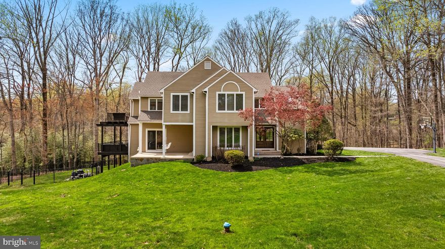 This architecturally impressive contemporary is located on 1.8 serene acres at the end of a cul-de-sac and boasts a stunning tiered deck that overlooks the magnificent inground pool with a waterslide and the expansive patio with fireplace and multiple seating areas - all encircled by stunning views of the woods. The interior features soaring ceilings, tons of windows, family room with a stately stone fireplace off the eat-in kitchen and a sprawling primary suite that includes a custom dressing room, laundry and luxury bath with soaking tub, oversized shower and gorgeous custom cabinetry.  The spacious lower level offers a large rec room area, 5th bedroom & full bath, exercise room and plenty of storage space! For every night of the week and special entertaining events, this unique contemporary supports spaces for everyone both inside and out!