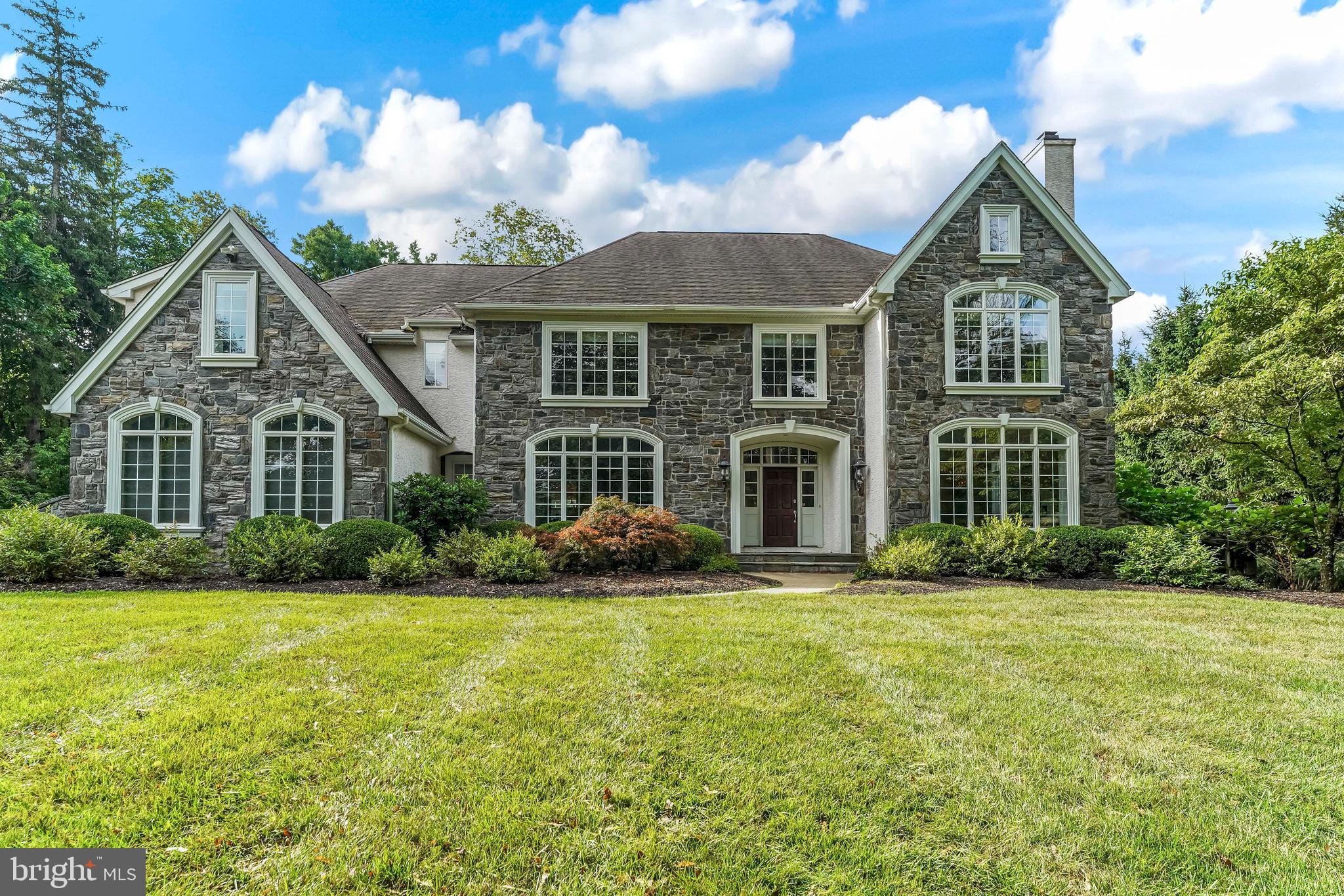 One of the area’s most extraordinary homes in one of the most desirable locations is now available. Quarried gray fieldstone and spectacular arched casement windows create a majestic presence on approach. You want for nothing in this magnificent property, buffered by woods adjacent to the conserved Brandywine Battlefield. This home is sited on 2+ secluded acres, yet close to everything. You will appreciate the high quality construction from Megill Homes, the Brandywine Valley’s premier custom home builder. Inside, a gracious flagstone front porch opens to a front to back foyer, and generous room sizes throughout the home. The brilliant floor plan provides for a “living wing” of the home that includes the kitchen with Viking appliances and Subzero fridge, informal dining area, a family room with stone fireplace and vaulted ceilings and a wall of windows to the fenced back yard and woods. Access to the low maintenance composite deck is from both the informal dining area and the main foyer, and the sun room.
The “west wing” of the home includes the formal living room with fireplace, office and sunroom. The formal dining room and butler’s pantry will comfortably host your events. Use the main or back staircase to go up to the bedroom level. The primary bedroom suite is over the west wing, creating an oasis with walk-in closets and bathroom backing to the woods. On the east wing, four additional guest bedrooms all with en suite bathrooms, and abundant closets. To the walkout lower level, an additional guest bedroom, full bathroom, recreation room, theater room, and additional open area for entertaining and gathering. All of your power needs are secure with 3x 200 amp panels, a backup generator, and a 50 amp EV outlet in the garage. Outside, the property includes a fenced vegetable garden that currently produces eggplant, shishito, bell, and hot peppers, cantaloupe, blackberries, several tomato varieties, and an herb garden with sage, mint, basil and thyme. Serviced by the highly rated Unionville-Chadds Ford School District, and close to numerous private schools in both Pennsylvania and Delaware. Nearby amenities include both upscale and everyday shopping and dining. Within 10 minutes is Whole Foods, Wegmans, Giant, Target, Pottery Barn, Anthropologie. Minutes to access to US-1, Philadelphia airport (22 miles/35 minutes), Wilmington Amtrak (14 miles/30 minutes).