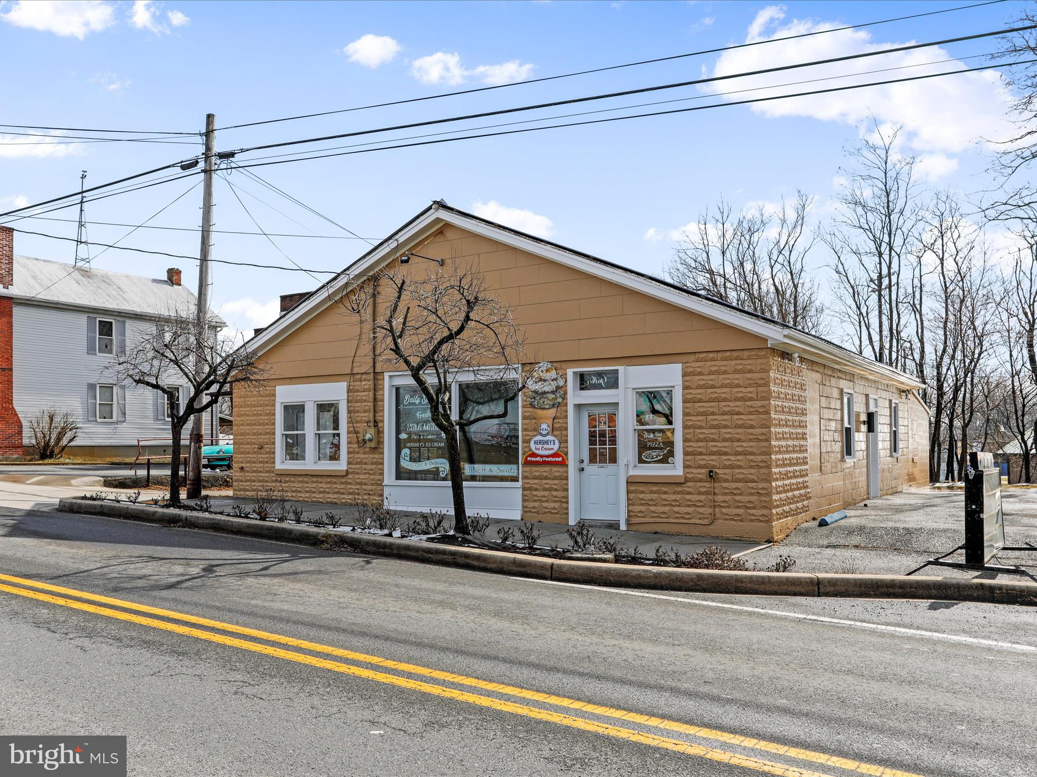 Outstanding Opportunity in Clear Spring, MD! Seize the chance to own a prime 1.55-acre corner lot property situated directly across from Clear Spring Schools and adjacent to local baseball fields and a sports park. This one-level, 2,440 square foot building, previously operated as a popular restaurant and ice cream shop. The property comes fully equipped with all necessary kitchen appliances and dining furniture, making it turnkey for culinary ventures or adaptable to other business needs. Recent upgrades include new epoxy flooring, HVAC system, fresh paint, and renovated bathroom. Strategically located just minutes off I-70 and less than 7 miles from Whitetail Mountain Resort, the property benefits from significant exposure due to its high-traffic location and ample parking space, ensuring convenience for both staff and customers. Washington County has this in RT zoning. Buyers to confirm with county all potential uses.