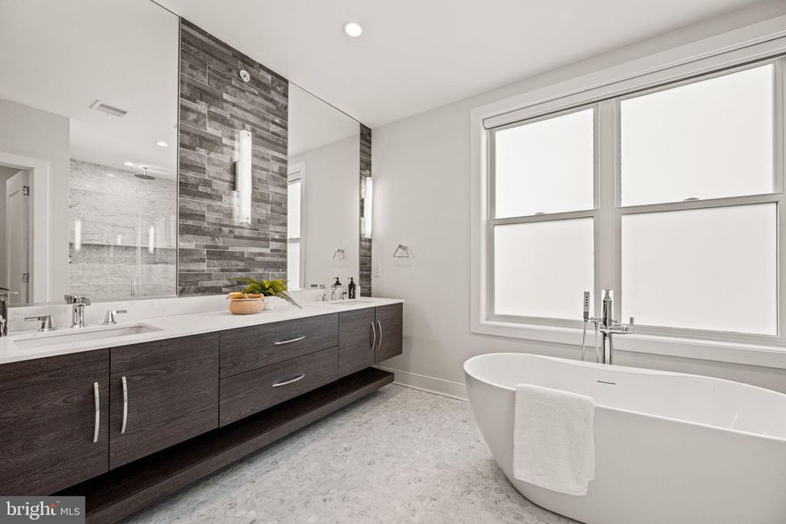 This home has a tax abatement through 2029. At 1217 Bainbridge Street, it begins the moment you arrive. Through the foyer, you’ll find a spacious TWO Car garage, an uncommon luxury in the heart of the city. Just beyond, a flexible bonus space awaits: home gym, art studio, or media room, the choice is yours. Up one level, the main floor unfolds into a space designed for entertaining or relaxing. Soaring 11-foot ceilings and floor-to-ceiling windows flood the living room with natural light. from south facing windows. The floating staircase becomes a sculptural centerpiece, guiding you toward a true chef’s kitchen: Wolf gas range, Sub Zero refrigerator, sleek quartz counters, 46” cabinets, and a large dramatic island with wine fridge. Just outside, a private grilling terrace adds a fresco charm. On the next level, you’ll find two generously sized bedrooms, one with its own en-suite bathroom plus a full hall bathroom. The laundry room is tucked here too, with a full sized side by side washer and dryer, custom cabinetry, and a folding counter to make life easy. And then there's the top floor: a full-floor primary retreat. Your spa-inspired bathroom features radiant heated floors, Carrara marble, rainfall shower, freestanding soaking tub, and dual floating vanities. A walk-in closet, dry bar, and private powder room elevate the experience further. From here, step onto the rooftop deck with built-in speakers, water, and electric, your own sky-high living room with city views. Wide-plank hardwood floors, centralized vacuum, Sonos® audio system, and custom lighting throughout the home complete the picture. A tax abatement through 2029 adds value. Set in Bella Vista, steps from Whole Foods, Sprouts, Rittenhouse Square, the Italian Market, and Washington Square, this home offers the space with the walkability to all of the culture of Philadelphia’s most beloved neighborhoods.