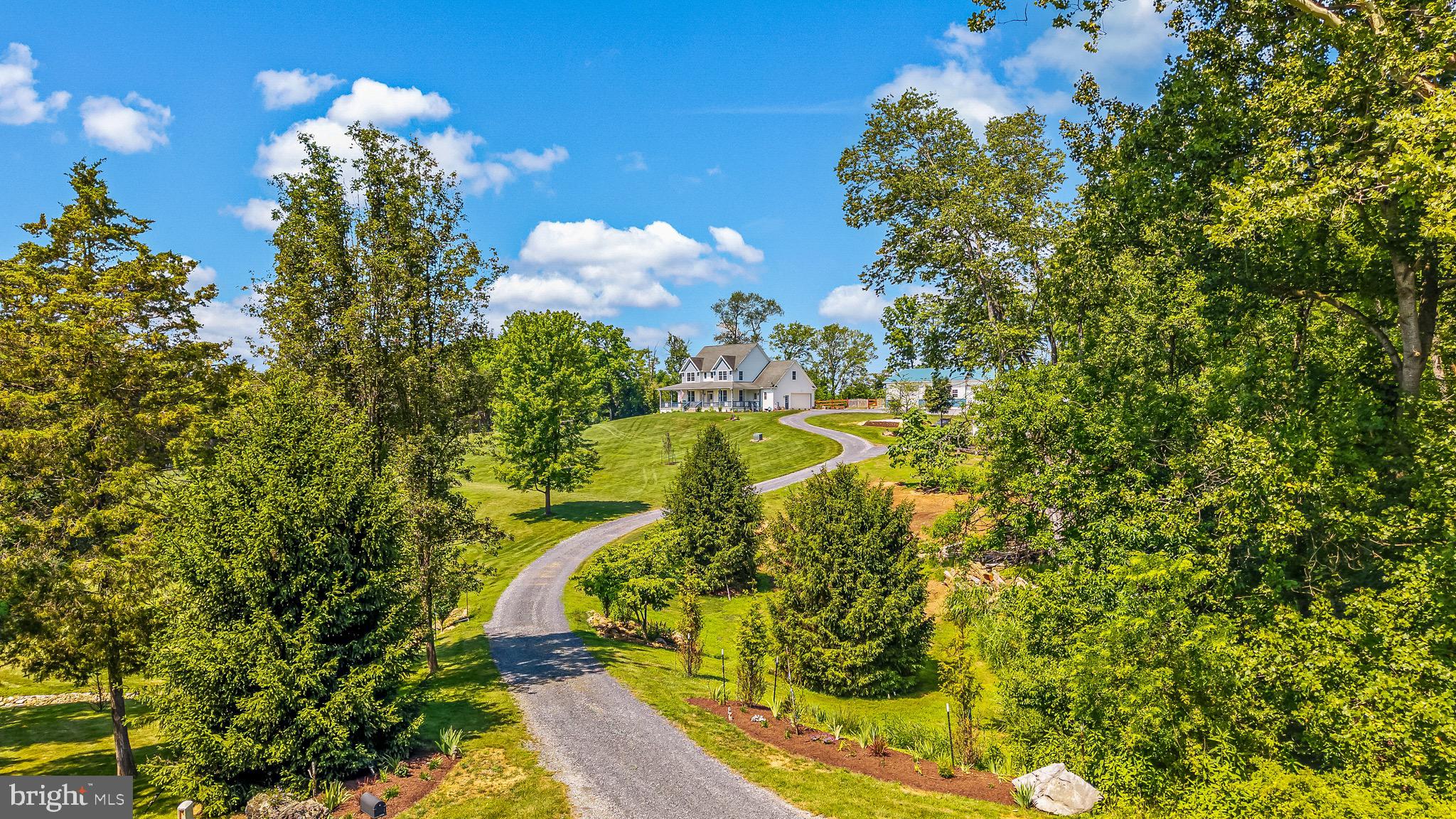 This is the one you’ve been waiting for, situated on 6.13 acres of peaceful land at the end of a quiet cul-de-sac. This stunning property offers breathtaking views of Maryland Heights, surrounded by lush woodlands, an abundance of wildlife, and 100 ft of community riverfront access. A custom-built home that combines the serenity of a country retreat with the luxury and convenience of modern living. Whether you seek privacy, tranquility, or Potomac River access, this property has everything! As soon as you arrive, the expansive wraparound front porch invites you to enjoy stunning sunrises. The back porch is the ideal spot to unwind and take in unforgettable sunsets over open farmland. This impeccably maintained 4-bedroom, 4-bath home has an additional bonus room in the basement (potential 5th bedroom). Home boasts over 3,700 sq ft of living space, thoughtfully designed for one-level living, with timeless details and a range of high-end upgrades. Inside, you will find a main-level primary suite with tray ceiling, a walk-in cedar closet, a private bath with soaking tub, and direct access to the back porch. There is a full bath on the main level for guests. Upstairs, there are 3 additional bedrooms with a full bath, perfect for family or visitors. Seperate office with built-in shelves, separate dining room, and main-level laundry. The custom kitchen with granite countertops, a large island, gas stove, and an open-concept layout. Beautiful hickory hardwood floors throughout the main level, tray ceilings, and crown molding. Gas fireplace in the living room, plus a wood-burning fireplace in the walkout basement. The partially finished basement has a full bath and its private patio, offering additional living space. Outside, you will find a brand-new concrete patio, ideal for entertaining or relaxing. Attached 2-car garage plus a massive one-of-a-kind 40x60 detached garage with a metal roof and electric, perfect for vehicles, storage, or hobbies. Two-story shed for extra storage or workshop space. Newly fenced-in backyard, 3 new towering Norway spruce trees in the front, and meticulously landscaped grounds. Generac 20kW generator, underground 500-gallon propane tank, and gas line on the back porch for barbecues. Underground utilities are to preserve the natural beauty and unobstructed views. 100 feet of private community access to the Potomac River, perfect for kayaking, fishing, and swimming. Conveniently located between Harpers Ferry and the Antietam National Battlefield, with unique shopping, dining, wineries, and breweries. Just minutes from hiking, biking, and outdoor adventures along the C&O Canal and Potomac River trails. Located near the MARC train, commuting is a breeze. Quiet, low-traffic cul-de-sac location for ultimate privacy. This home strikes the perfect balance between seclusion and accessibility, offering a peaceful retreat in the highly desirable Shepherdstown, yet just a short drive from nearby attractions. Surrounded by nature, filled with charm, and designed for comfort, this is your very own slice of paradise. Don’t let this opportunity slip away! HOA HAS VERY LIGHT RESTRICTIONS. Showings by appointment only. Proof of funds or pre-approval letter only. Please, no driving up the driveway without an appointment.