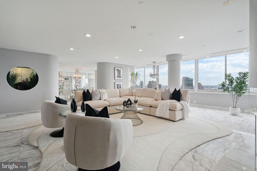 One-of-a-kind custom-built two bedroom plus den (originally built as a three bedroom that can be converted back), two and a half bathroom penthouse at the highly coveted Residences at The Rittenhouse Hotel. The residence offers magnificent views of the park from almost all rooms, tremendous entertaining spaces, and luxurious bedroom suites. A great opportunity to move right in or customize to your own specs and desires.  Enter the home through a foyer that leads into the open great room. The sun-filled great room features a full wall of oversized windows, recessed lighting, marble flooring, and a fireplace. The marble floors continue into the light-filled dining room that features a gorgeous chandelier, wall of mirrors, and access to the balcony with breathtaking views of Rittenhouse Square and Center City. The fully equipped chef’s kitchen features white cabinetry, granite countertops, a spectacular built-in fish tank, and a high-end appliance package that includes a JennAir range, Miele dishwasher, Kitchen Aid ovens, Sub-Zero refrigerator, and GE microwave. Adjacent to the great room is the cozy den that includes wood floors and a large built-in entertainment system with wet bar and beverage fridge. The primary bedroom boasts excellent closet space, more natural light, wood floors, and an extravagant ensuite bathroom. The primary bathroom is appointed in black marble and features three large vanities, jacuzzi tub with a stunning view, and glass stall shower. There is a second bedroom with more natural light and wood floors that enjoys use of a full ensuite bathroom with stall shower. Additional unit highlights include a powder room, laundry room with LG washer and Miele dryer, and excellent closet and storage space throughout. The condominiums at The Rittenhouse sit atop the five-diamond Rittenhouse Hotel. Residents of The Rittenhouse enjoy the use of a chauffeur-driven town car, concierge, and 24-hour lobby attendant. And for an additional fee they can enjoy the same amenities as hotel guests, including valet parking, housekeeping services, room service, spa and fitness center, indoor pool, dog walking, the newly renovated Paul Labrecque Salon, and Lacroix Restaurant.