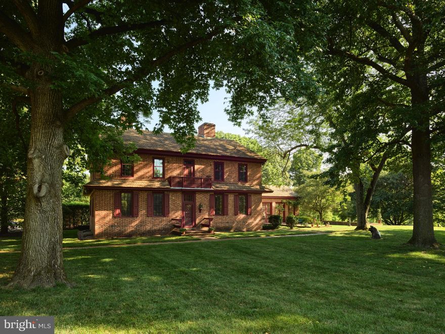 Located on 22 bucolic acres in Chester County, the William Peters House offers authentic 18th-century features with cleverly camouflaged 21st-century amenities. Originally constructed in 1750 and now on the market for the first time in 60 years, this prestigious Georgian-style home awaits the next stewards in its long and storied history. At 6,046 square feet, the three-story home offers six bedrooms and four and a half baths, a cozy library with built-in bookcases, a formal dining and living room, and an original 18th-century kitchen with a large, walk-in fireplace. A total of nine wood-burning fireplaces have been meticulously restored, and the more modern amenities, such as the multi-zoned heating and cooling systems and a full house generator, are all invisible under the house's historic interior. Original wood paneling throughout includes unusual recessed panels, restored mantels, and multiple built-in display cupboards, while the windows contain wavy, handmade glass. Outlets and registers are hidden in baseboards and light switches concealed below chair rails for an authentic 18th-century experience. In 1963, the Georgian-style house was relocated and lovingly reconstructed to exact replication by Judith and John Herdeg. John, who served on the board of Winterthur for 50 years, and Judith worked with local historical architect Albert Kruse. Listed on the National Register of Historic Places, the property includes period-appropriate gardens of native plants, planned in coordination with world-renowned Belgian landscape architect Francois Goffinet. In 1994, an orangerie was added with soaring ceilings, heated terracotta floors, a large fireplace, and 10-foot tall glass-paneled doors that allow in great swells of natural light.  An ideal space for entertaining, the orangerie contains an intimate bar, French doors that open into a sunken lawn, and a brick patio with a screened-in porch overlooking alighted allee of maple trees to the north. More recent additions to the house include an expansive, renovated chef's kitchen with a large island and curved bank of cabinets offering amenities to accommodate modern living, including abundant storage. A room-sized cedar closet and an elevator with basement, first and second floor access additional modern conveniences. Despite its august provenance, the Herdegs' raised an active family who thrived in the secluded setting. Homeowners and visitors enter the property via a large, floral iron entrance gate, then proceed down the long, curved drive. An eight-foot-tall deer fence protects the native gardens and encircles some forest and a back stream. Within the fencing there is ample space for a horse barn and livestock grazing.