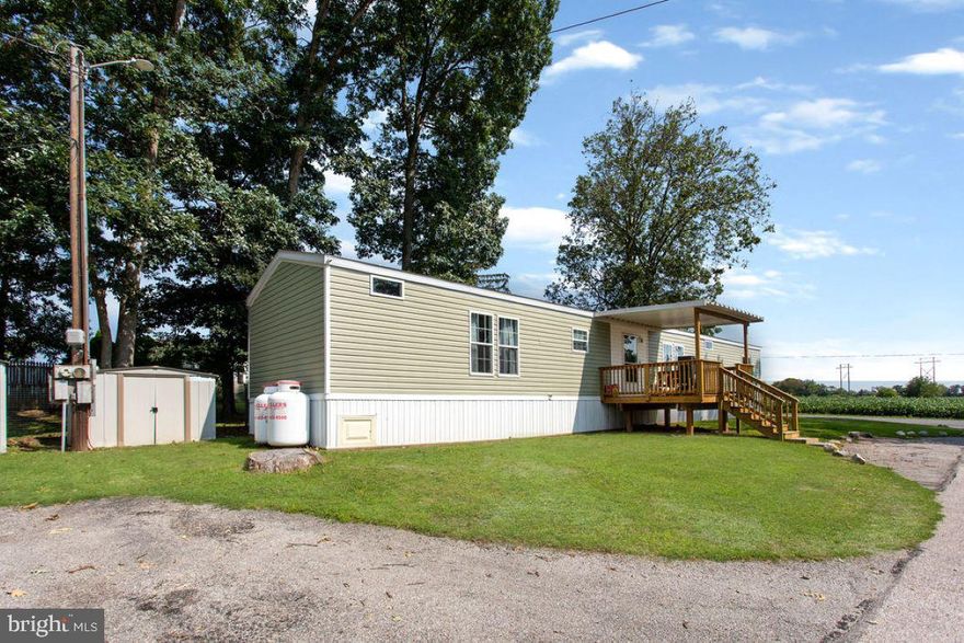 Stunning 2 bedroom, 2 bath single wide mobile home with open floor plan. Beautiful floors throughout the home. Big living room opens to dining area and large eat-at island in kitchen - all with cathedral and exposed beam ceilings. Owner's suite complete full bath and walk-in closet.  Covered front porch. Corner lot. Buyer must be approved by park.  (interior pictures coming soon)