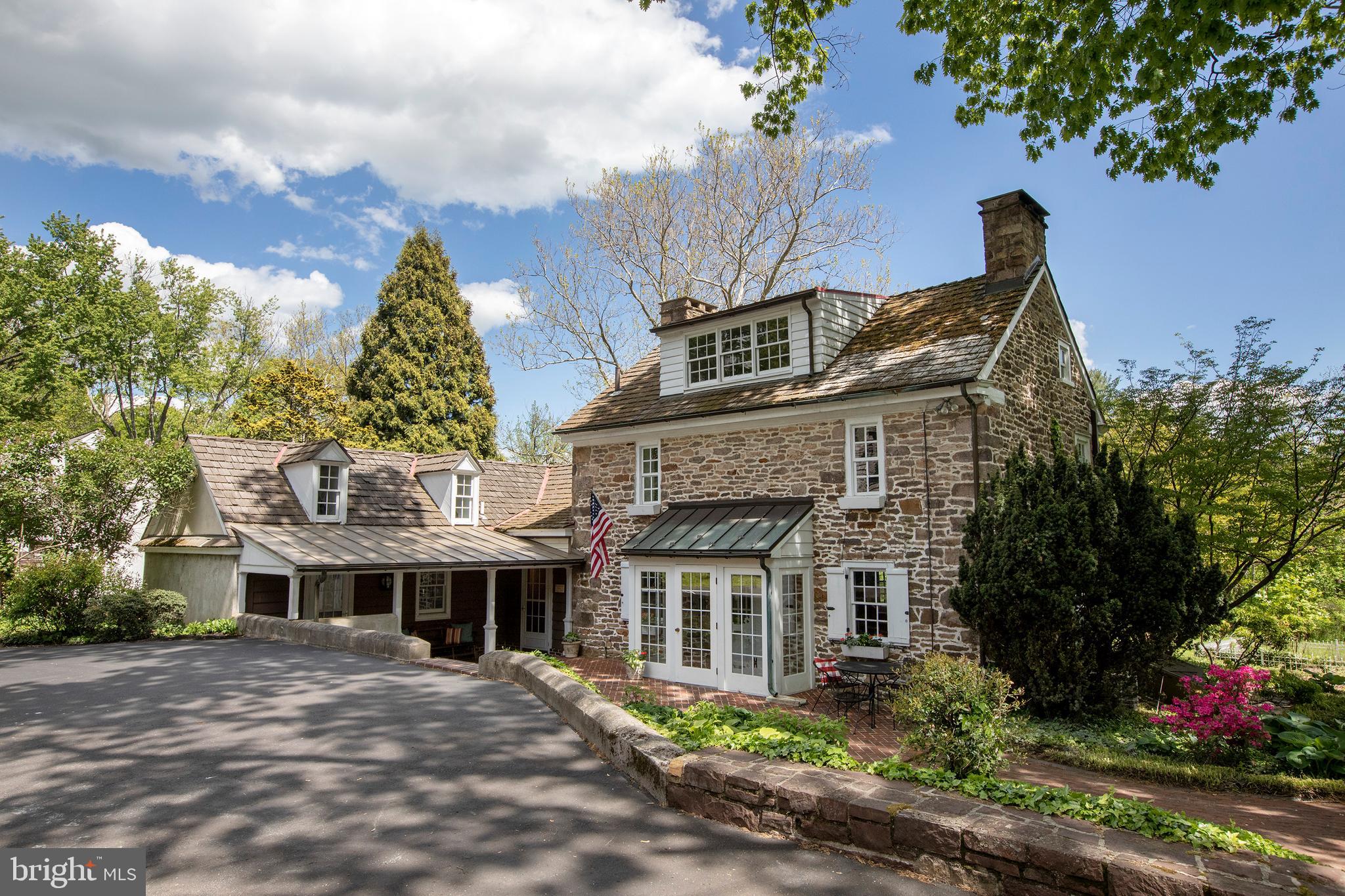 The John Fell House, circa 1733, is a one-of-a-kind Doylestown Borough property that offers a tremendous opportunity to own a piece of history on a sprawling estate-like compound. Over two acres of park-like land and set back down a long driveway, this property was reportedly the location of George Washington's headquarters when the Continental Army camped at Doylestown in the summer of 1778. The antique stone manor house retains all of the charm and character of classic Bucks County, without sacrificing modern amenities thanks to a 21st century full scale renovation. Finely landscaped grounds are full of natural light in the mostly Southern-facing front yard. An exposed stone entry hall greets you at the primary entrance on the manor house, leading to the large updated kitchen featuring a 14' cathedral ceiling, 6+2 Viking professional range with double oven, side by side SubZero fridge, and plenty of storage. A main-level master suite was envisioned in the adjacent keeping room, with a full bathroom roughed in and ready for finishing, this space could also lend itself well to an au pair or live-in help and has a second floor loft above. The Southern-facing sunken living room room makes a great library and has also served as the formal dining room for the home, overlooking the grounds. The original section of the stone home retains the classic walk-in 9' fireplace complete with beehive oven and gate arm hardware. Upstairs you will find two additional bedrooms, both nearly the length of the original home, with wide plank floors and exposed beams. A 3 bedroom guest house is large enough to be split into an upstairs pool house and downstairs home office or guest suite, and oversized 4 car garage with workshop loft backs up to the in-ground pool. Picture perfect down to the original stone spring house, truly a once-in-a-generation opportunity in the Borough.