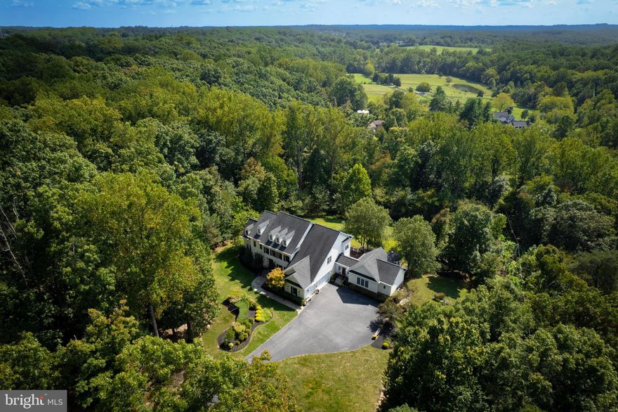 Welcome to this exquisite home where ambiance graces you through this private setting, centrally located in the heart of Highland! This 6 bedroom, 6 bathroom 9000+ sf home has an open floor plan and a grand two story foyer. The formal Dining Room is perfect for dinner parties or quaint gatherings featuring the stunning decorative tray ceiling, wall sconces, picture frame trim, chair rail, hard wood flooring and a beautiful chandelier accentuated by an ornamental medallion.  The formal Living room leads you into the breathtaking Conservatory with walls of windows allowing mother nature’s sundrenched warmth and light to freely flow throughout. The Gourmet kitchen is a chef’s dream featuring an enormous center island, under cabinet lighting, granite countertops and Thermador cooking appliances, allowing ample space for culinary adventures! The Kitchen is open to the Great Room that invites you to cozy up in front of the two-sided stone fireplace during those chilly Fall or Winter days to be enjoyed with family and friends as you create memories of story-telling, game playing, movie night or entertaining friends and family. The Great Room features a beautiful tray ceiling, access to the screened-in porch, and also opens to a large breakfast room with deck access. A private two station office/work area is off the Kitchen, and has proven to be a great space for homework or personal affairs. This area leads to a large walk-in pantry. The expansive screened-in porch with fireplace provides a spectacular space for entertaining, or a quiet meditative atmosphere with spectacular pastoral views. First floor bedroom can also be used as a large office/den. Just outside of the first floor bedroom is a full bath.  

As you venture past the Kitchen, you will discover the mudroom with a custom bench and cabinetry ideal for storage that leads you to the oversized three car garage. From the mudroom is a breezeway with access to the front driveway as well as an access door to the rear deck. As you continue through the breezeway, you will enter the spacious In-law suite with Dining room, Living room, Kitchen, large Bedroom and full bath. This in-law suite has another access door open to the expansive deck with gazebo overlooking the beautiful back yard.

The private upper level of the main house has a spacious primary bedroom providing a serene retreat with large sitting room and luxury bathroom with soaking tub, separate shower for two, private water closet, separate dual sinks, his/her walk-in closets and leads you into a private exercise room, prayer room or nursery. There are two additional spacious bedrooms with their own private bathrooms and private sitting rooms. The Loft library could easily be converted to another spacious bedroom. The large laundry room with built-in cabinetry and countertops complete this level.

The Lower level is an exceptional area for entertaining, family gatherings and Sunday Football games! The full-sized antique built-in bar is also great for ice cream parties, or a popcorn station for movie and game night.  The recreation area with pool table connects to the family room with theatre seats,  built-in speakers, panoramic gas fireplace, a hobby/craft area, game room/office/den and a spacious bedroom with full bath.  The walk out leads to a large flagstone patio with stone retaining wall, built-in gas grill, wood burning stone fire pit and hot tub.  You don’t have to go anywhere else to have fun, when this house has it all!  

This 10+ acre lot is located at the end of a cul-de-sac and is very private.  The back yard has a delicate mix of lush landscape allowing nature and wildlife to share a beautiful existence with you.  As you wander through the wooded area, you will come upon a meandering stream where the sounds of tranquility will fill your senses.  The property is lined with a partially fenced area.  Great location with River Hill Schools and close to major commuting routes.  Perfection personified!