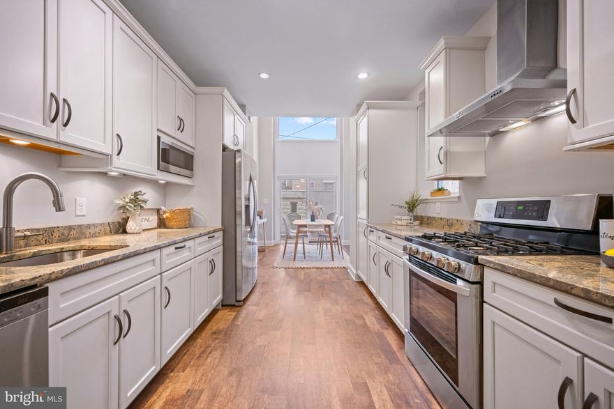 Live in the heart of Baltimore’s iconic Little Italy in this grand, four-level brick townhome where timeless charm meets unforgettable city living. From the moment you step inside, you’re welcomed by expansive proportions and a show-stopping staircase that sets the tone for the entire home. Rich, dark wood floors and exposed brick walls create a warm, romantic atmosphere that perfectly complements the historic character of the neighborhood.

The home has been thoughtfully enhanced with custom details designed to create ambiance at every turn. Elegant wall sconces provide soft mood lighting, adding warmth and character throughout the living spaces. The kitchen features its own layered lighting design, including intentional mood lighting to elevate evening dinners and entertaining. Most switches throughout the home are dimmer-controlled, allowing you to curate the perfect atmosphere — whether hosting a lively gathering or enjoying a quiet night in. Adding to the home’s artistry is a beautiful handmade stained glass interior window, a unique architectural feature that brings character, color, and timeless charm to the space.

Enter through the living room and continue toward the rear of the home where the kitchen opens to an impressive dining area with soaring 20-foot ceilings—an incredible backdrop for dinner parties, holidays, and memorable gatherings. Just beyond, step onto your private, gated patio, an intimate outdoor retreat where string lights glow overhead and the sounds of Little Italy drift through the evening air. Imagine a summer night: soft jazz playing, a hint of Sinatra in the background, and the energy of the neighborhood just outside your gate. The rear patio is fully enclosed for privacy and also offers gated access with the option to convert the space into private parking in the future, though ample street parking is typically available. A convenient half bath completes the main level.

The second floor features two spacious bedrooms, a full bathroom with a marble sink and classic checkered flooring, and a dedicated laundry area. One of the bedrooms boasts a large walk-in closet, offering excellent storage and flexibility for guests, home office, or additional living space.

The entire third level is dedicated to the owner’s suite, a true retreat featuring a private balcony with city skyline views, including glimpses of the Four Seasons and Inner Harbor skyline just a five-minute walk away in Harbor East. The suite includes a huge walk-in closet and an oversized spa-style bathroom, creating a luxurious and private top-floor sanctuary.

The full basement, spanning the footprint of the home with approximately 7.5-foot ceilings, offers abundant space for storage, a workshop, fitness area, or future finished living space.

Located just steps from the renowned restaurants, cafés, and festivals of Little Italy—plus the waterfront, Harbor East, and the Inner Harbor—this home offers a lifestyle as special as the property itself. Enjoy evenings strolling to dinner, espresso at Vaccaro’s, neighborhood festivals, and waterfront walks under the city lights.

A rare opportunity to own a spacious, character-filled home in one of Baltimore’s most beloved and vibrant neighborhoods.