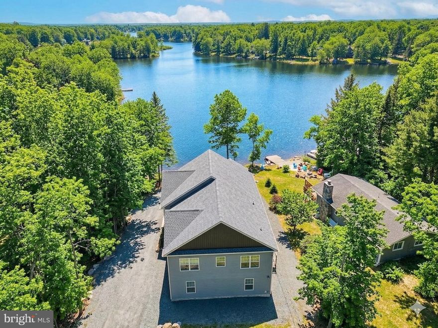 Welcome to Sunset Horizon, a fully amenitized, newer construction, turnkey lakefront retreat in the highly sought-after and STR-friendly Arrowhead Lakes community—a rare combination of prime location, guest experience, and income potential.

This true lakefront property delivers the full waterfront lifestyle, featuring unforgettable views and a strong amenity package, plus an additional 600+ sq ft unfinished space currently being completed, offering a blank canvas for future value-add features.

Set yourself apart from the competition with premium outdoor features including private lake access, an expansive deck overlooking the water, a hot tub with lake views, fire pit for year-round enjoyment, and covered outdoor dining—all designed to enhance guest experience and drive bookings.

Spanning approximately 3,400 sq ft, the home offers 5 bedrooms and two oversized bonus rooms, providing ample space for large groups, events, and high-revenue stays.

Originally designed by an owner/architect with both experience and revenue in mind, the home features a bright, open-concept layout with vaulted ceilings and panoramic lake views, creating a warm yet elevated mountain-lake aesthetic.

The spacious living and dining areas are ideal for entertaining, while the fully equipped kitchen easily accommodates large gatherings.

Flexible sleeping arrangements—including king suites, a bunk room, and additional guest rooms—maximize occupancy and booking versatility.

This property features two large bonus spaces, designed to keep guests engaged year-round. The lower level includes a fully equipped game room, a major driver for family and group bookings.

An additional space—currently being converted from the garage—offers the opportunity to create custom, high-impact amenities such as an indoor pool, private theater, or wellness space, allowing you to further increase revenue potential.

Located within Arrowhead Lakes, guests enjoy access to 3 community pools, 4 beaches, tennis, basketball and volleyball courts, a playground, lodge, and fitness center, enhancing the overall guest experience and booking appeal.

Whether you're seeking a cash-flowing investment, a hybrid vacation home, or a lifestyle property that delivers both enjoyment and returns, this lakefront retreat checks every box.

Lakefront properties with this level of size, amenities, and income potential rarely come to market—don’t miss the opportunity to own a true top-performing asset in the Poconos.