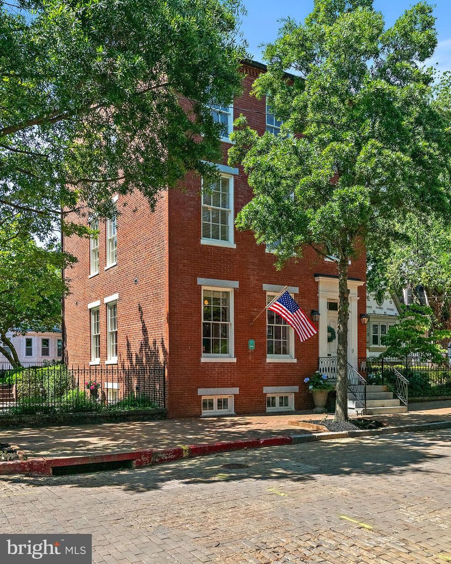 “A truly exceptional historic residence is now available in the heart of downtown Annapolis. Welcome to 16 Maryland Avenue, a distinguished circa-1830 Greek Revival home masterfully restored in collaboration with the renowned Hammond-Wilson Architects. Perfectly positioned just steps from State Circle and the United States Naval Academy, this iconic three-story brick property seamlessly blends timeless architectural beauty with sophisticated modern livability.
The main property features 4,474 square feet of refined above-grade living space, complemented by a fully legal, licensed lower-level apartment that offers immense versatility for multi-generational living or premium rental income. In total, the property features six bedrooms, 4.5 bathrooms, and beautifully curated living spaces defined by rich period details, soaring ceilings, and remarkable craftsmanship. Six fully rebuilt, functional wood-burning fireplaces (three equipped with gas starters) serve as stunning architectural focal points throughout the home.
Equally captivating are the enchanting outdoor spaces. Here, manicured grounds, lush landscaping, vibrant flower beds, and a serene koi pond create a private garden retreat rarely found downtown. Set on a prime 7,324-square-foot lot along one of the city’s most coveted historic streets, the property offers tranquility just moments from the waterfront and bustling downtown scene.
Zoned as a two-family residence, this remarkable property represents a rare, premium investment or a luxurious private estate. Residents will enjoy an unmatched lifestyle, surrounded by boutique shopping, acclaimed waterfront dining, art galleries, historic landmarks, and the unmistakable charm of Annapolis Harbor. Elegant, iconic, and rich with history, 16 Maryland Avenue represents downtown Annapolis living at its absolute finest.