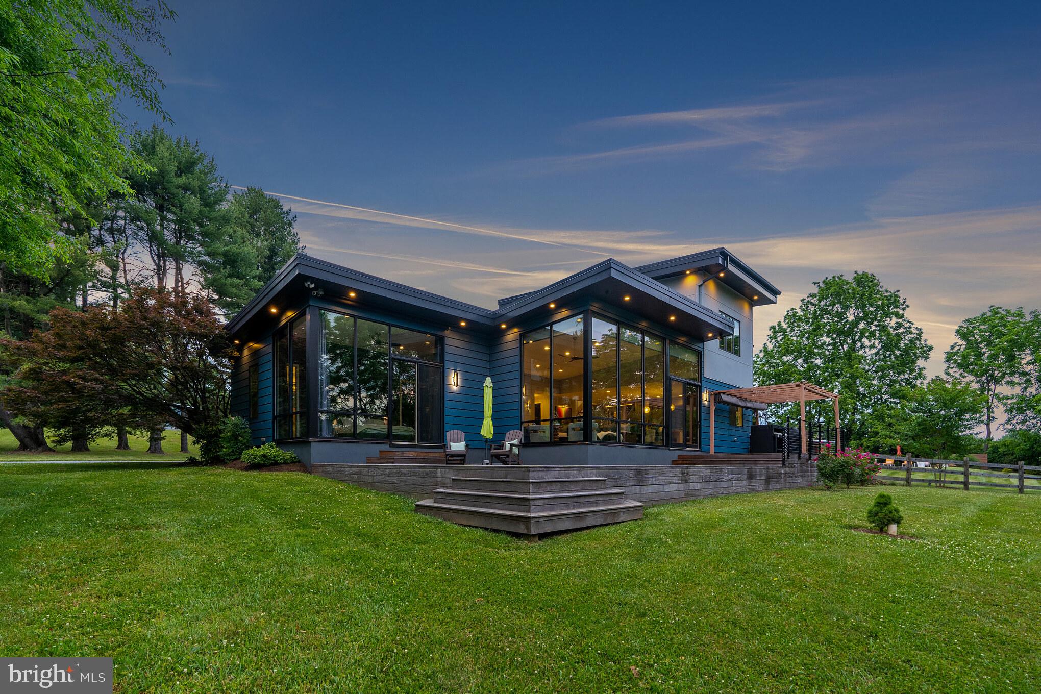 Welcome to this stunning contemporary home on over 5 gorgeous acres in Charlestown Twp. Move right in time to enjoy the gorgeous pool and grounds this home has to offer. Built-in 2016 with commercial-grade materials, this home has been built to last. Enter through the front door and you will be taken with the amazing views through the custom commercial glass wall system in the living room complete with exterior power shade. Marvin Ultrex fiberglass doors and windows throughout the home. The living room is open to the chef's kitchen complete with Thermador appliances, custom cabinetry, and gorgeous designer countertops including a walk-in pantry. The first floor has Mirage white oak quarter-sawn flooring in the living room and kitchen, and radiant floor heat throughout. Tall ceilings and custom 8 ft interior doors. A powder room is off of the living room. An 800 Sqft. Cumaru deck located off the living room, kitchen, and main bedroom provides the perfect spot for summer entertaining. Feel like you are sleeping outdoors in the first-floor primary bedroom with floor-to-ceiling windows. The luxurious primary bathroom feels like a spa with a large soaking tub, stand-up shower, two large vanities with plenty of storage space, and finished with designer tile and lighting. The primary bedroom has a large walk-in closet with a custom closet system. Work from home with gorgeous views in the office located off of the living room. Just off the kitchen is a convenient mudroom with a dog wash station and a powder room with easy access to the pool and yard. The laundry is also located on this level.
Walk up the custom-built staircase to the second floor with a huge bonus room and two additional bedrooms. A full bathroom services the two bedrooms on this floor. Second-floor design easily allows for an additional fourth bedroom and bathroom. The septic system is designed for 4 bedrooms.
The show-stopping grounds with 5-plus acres and a saltwater pool are truly an entertainer's dream. Enjoy summer evenings with amazing views and privacy. The pool has been redone with new plaster, filter, and heating equipment. The yard has been extensively landscaped and meticulously maintained with over 30 new plantings. A pool house is used for the storage of all your pool toys and pool furniture and is outfitted with electricity.
Additional details of this home are as follows: Geothermal with fresh air markup, Water softener, Moen automatic water shut off, No maintenance composite exterior, Insulated urethane wall panels, and custom siding over spray foamed walls, 2 car garage with Custom oversized garage doors, a Commercial grade roof system, Driveway was repaved, Shed with urethane walls and roof, Generator hookup with a transfer switch.
