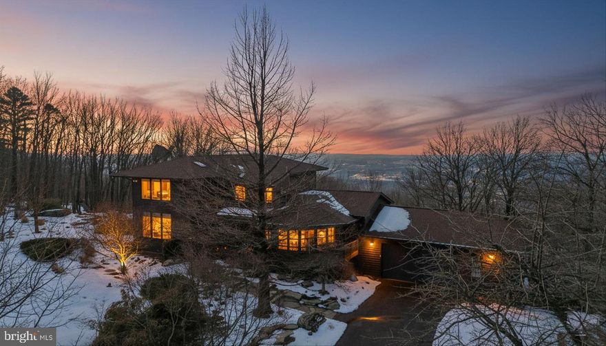 Perched high above the Shenandoah Valley, this private mountain retreat invites you to exhale.

Imagine mornings on the wraparound porch with coffee in hand as the Shenandoah Valley unfurls in the distance. Evenings drift easily from the screened rear porch to the expansive deck and stone patio, where sunset skies stretch for miles and stars feel close enough to touch. Two installed outdoor sculptures — a serene lotus near the front door and three striking crows near the stone patio, add artistic character and a sense of quiet whimsy to the landscape. This is the kind of place where weekends turn into traditions and year-round living feels like a permanent escape.

Set on 10 scenic acres just steps from the Appalachian Trail, this *Fully-Furnished* 3 bedroom, 2.5 bath home blends privacy, comfort, and modern reliability in a setting that feels worlds away. Inside, a dramatic two story family room is wrapped in windows that frame the breathtaking view of the valley below, with a gas fireplace anchoring the space for cozy mountain nights. The dining room opens directly to the rear deck, creating effortless indoor-outdoor living for gatherings- large or small.

The kitchen is designed for hosting, featuring stainless steel appliances, Black Morgan granite counters, a skylight that fills the space with natural light, and a nearby dry bar with built-in wine fridge. A formal living room or study overlooks the front porch, offering a peaceful space for reading, reflection, or remote work (with Xfinity internet service) with nature as your backdrop.

The main level primary suite provides a private retreat with its own ensuite bath, while two upper level guest bedrooms share a well-appointed hall bath. Hardwood, ceramic tile, and slate flooring add warmth and durability throughout.

Recent upgrades offer peace of mind, including a dual fuel Trane HVAC system, roof, chimney and skylights, water heater, whole house generator, upgraded alarm and auto lighting system, and high speed Comcast Xfinity internet. An oversized attached garage, generous driveway parking, and thoughtful landscaping complete the package.

Located minutes from the Shenandoah River and Lake Shannondale, and just steps from the Appalachian Trail, this Harpers Ferry mountain home delivers turnkey luxury in a setting that feels restorative, elevated, and undeniably special.