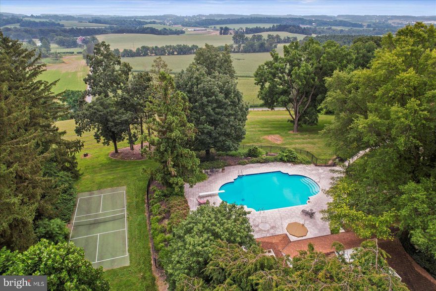 If you value privacy, exquisite views and a resort lifestyle, then look no further as this regal estate, high on the hill is sure to please!  With attention to every detail, this property presents an unmatched level of impeccable design. Enter through a gorgeous masonry pillared gate and be impressed by the tree-lined entryway as you are greeted with breathtaking views that go on for miles. Luxury exudes all around you on this 10+ acre, resort-style residence. An expansive renovation of the entire property showcases this one-of-a-kind custom property for one with distinguished taste. Enter through the double doors to the grand two-story foyer featuring two closets and a settee. Go upstairs and discover two bedrooms complete with walk-in closets and a full bath or continue on the first floor to the massive main living room area with exposed wood beams, a fireplace with beautiful stonework and even a wet bar to service this room. Follow the French doors to the dining room and discover the wall of windows with the extensive, scenic views on full display. Here you will also find a multi-level outdoor terrace, with landscaping to complement the round paved terrace leading to the pool.  Also in the dining room is a bar pass-thru and plenty of room to entertain noted by the oversized dining room table. The kitchen boasts beauty and grandeur that any chef would love. With a portable island, ss appliances and an imported backsplash from Italy, this bright and welcoming kitchen will make creating dinners a delight. The first-floor primary ensuite features 4 closets, 2 sinks, a vanity, dual shower heads, soaker tub, linen closet, and a separate WC. A delightful office space with built-ins and a powder room across the hall make the owners wing a private, personal space. Stroll down the hall to the East Wing and on your way find the meditation room. Here you can enjoy your morning workout with a large fountain, plant life, a 6-person sunken hot tub and powder room. There is a massive dome style skylight above that adds plenty of natural light or enjoy your evenings to gaze at the stars when you wind down from a long day. Continue down the hall to find a French-styled Great room, fit to impress! With 16’ ceilings this spectacular space knows no limits with the enormous fireplace, built-ins, wet bar, mini fridge, motorized cabinet lift TV, stunning chandelier (also on an electric pulley system) and massive windows framing the French doors to the terrace. There is ambiance at every turn of this residence, and the China Room is just one more example. This is a great place for afternoon tea, to host a luncheon, or to enjoy a great novel on the bench seat by the large bay window. Do you enjoy gardening? There is an attached greenhouse with Humidistat/Thermostat; it is a true horticulturists delight! The pool house features a stunning white stone fireplace, water skid-safe ceramic tile floor, skylight, soothing color palate, open-air concept and everything needed for perfection in entertaining as well as two, twin bedrooms!  Be sure to visit the newly resurfaced pickleball court with stunning views and after a game relax those muscles in the sunken, outdoor hot tub or take a dip in the heated 50,000-gallon pool, with dive. This property offers dream-worthy outdoors, mature landscaping and vista views that are unending! There is parking overflow for 26 cars. With just over 10 acres this property is Clean & Green. The main house is a total of 7,249 sq feet. The pool house is a total of 2,561 square feet. Both have been freshly painted to offer a heartfelt welcome to you and your guests. There are 5 bedrooms and 5 baths between both properties.  Location Location Location.  This Estate is like no other. Come and live your best life, every day, on the hill at 6759.