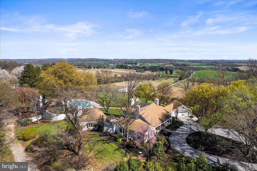 If you value privacy, exquisite views and a resort lifestyle, then look no further as this regal estate, high on the hill is sure to please!  With attention to every detail, this property presents an unmatched level of impeccable design. Enter through a gorgeous masonry pillared gate and be impressed by the tree-lined entryway as you are greeted with breathtaking views that go on for miles. Luxury exudes all around you on this 10+ acre, resort-style residence. An expansive renovation of the entire property showcases this one-of-a-kind custom property for one with distinguished taste. Enter through the double doors to the grand two-story foyer featuring two closets and a settee. Go upstairs and discover two bedrooms complete with walk-in closets and a full bath or continue on the first floor to the massive main living room area with exposed wood beams, a fireplace with beautiful stonework and even a wet bar to service this room. Follow the French doors to the dining room and discover the wall of windows with the extensive, scenic views on full display. Here you will also find a multi-level outdoor terrace, with landscaping to complement the round paved terrace leading to the pool.  Also in the dining room is a bar pass-thru and plenty of room to entertain noted by the oversized dining room table. The kitchen boasts beauty and grandeur that any chef would love. With a portable island, ss appliances and an imported backsplash from Italy, this bright and welcoming kitchen will make creating dinners a delight. The first-floor primary ensuite features 4 closets, 2 sinks, a vanity, dual shower heads, soaker tub, linen closet, and a separate WC. A delightful office space with built-ins and a powder room across the hall make the owners wing a private, personal space. Stroll down the hall to the East Wing and on your way find the meditation room. Here you can enjoy your morning workout with a large fountain, plant life, a 6-person sunken hot tub and powder room. There is a massive dome style skylight above that adds plenty of natural light or enjoy your evenings to gaze at the stars when you wind down from a long day. Continue down the hall to find a French-styled Great room, fit to impress! With 16’ ceilings this spectacular space knows no limits with the enormous fireplace, built-ins, wet bar, mini fridge, motorized cabinet lift TV, stunning chandelier (also on an electric pulley system) and massive windows framing the French doors to the terrace. There is ambiance at every turn of this residence, and the China Room is just one more example. This is a great place for afternoon tea, to host a luncheon, or to enjoy a great novel on the bench seat by the large bay window. Do you enjoy gardening? There is an attached greenhouse with Humidistat/Thermostat; it is a true horticulturists delight! The pool house features a stunning white stone fireplace, water skid-safe ceramic tile floor, skylight, soothing color palate, open-air concept and everything needed for perfection in entertaining as well as two, twin bedrooms!  Be sure to visit the newly resurfaced pickleball court with stunning views and after a game relax those muscles in the sunken, outdoor hot tub or take a dip in the heated 50,000-gallon pool, with dive. This property offers dream-worthy outdoors, mature landscaping and vista views that are unending! There is parking overflow for 26 cars. With just over 10 acres this property is Clean & Green. The main house is a total of 7,249 sq feet. The pool house is a total of 2,561 square feet. Both have been freshly painted to offer a heartfelt welcome to you and your guests. There are 5 bedrooms and 5 baths between both properties.  Location Location Location.  This Estate is like no other. Come and live your best life, every day, on the hill at 6759.